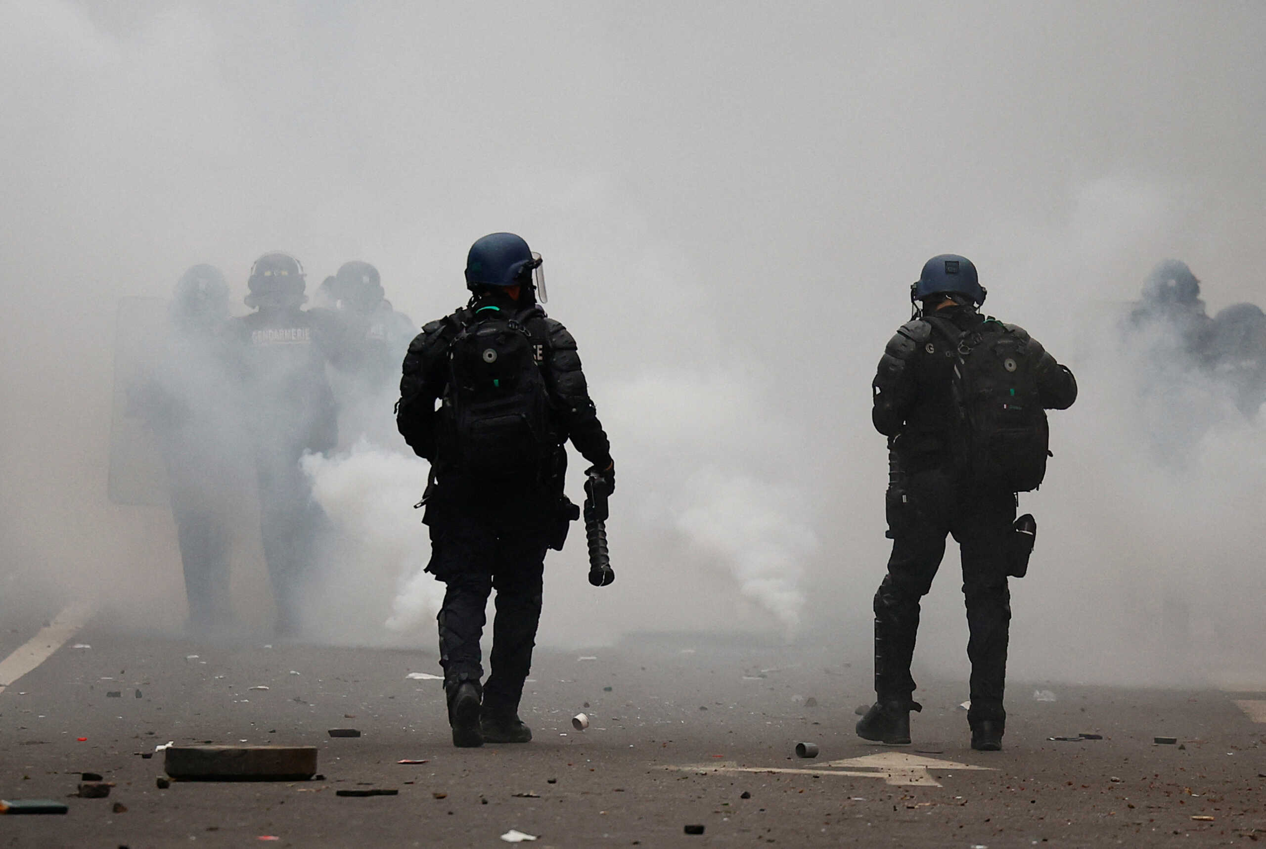 A French riot police officer holds an LBD (defensive ball launcher) weapon, as members of the Kurdish community attend a demonstration, following a shooting, in Paris, France December 24, 2022. REUTERS