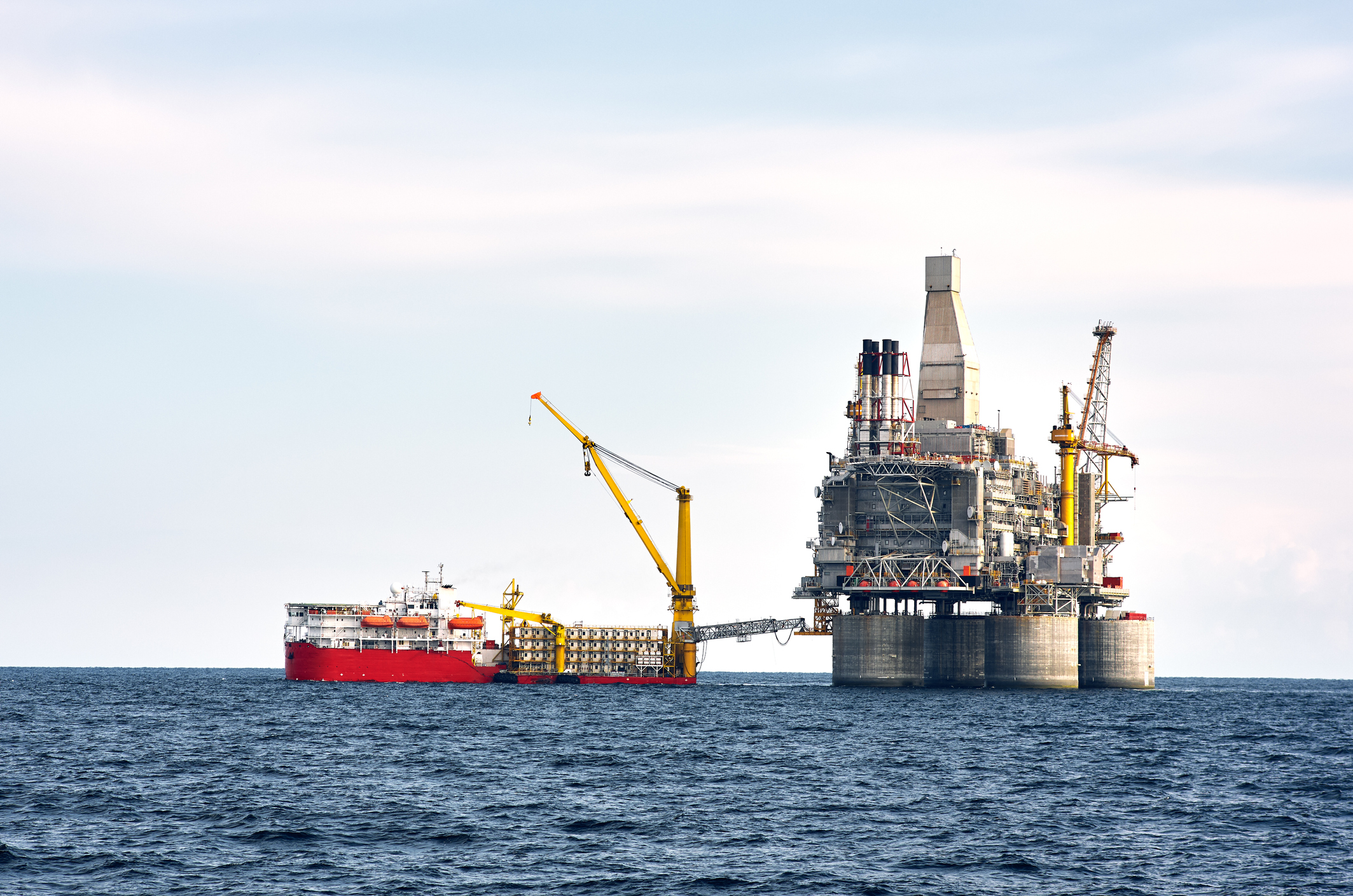 Drilling rig and support vessel on offshore area, sea and clean blue sky