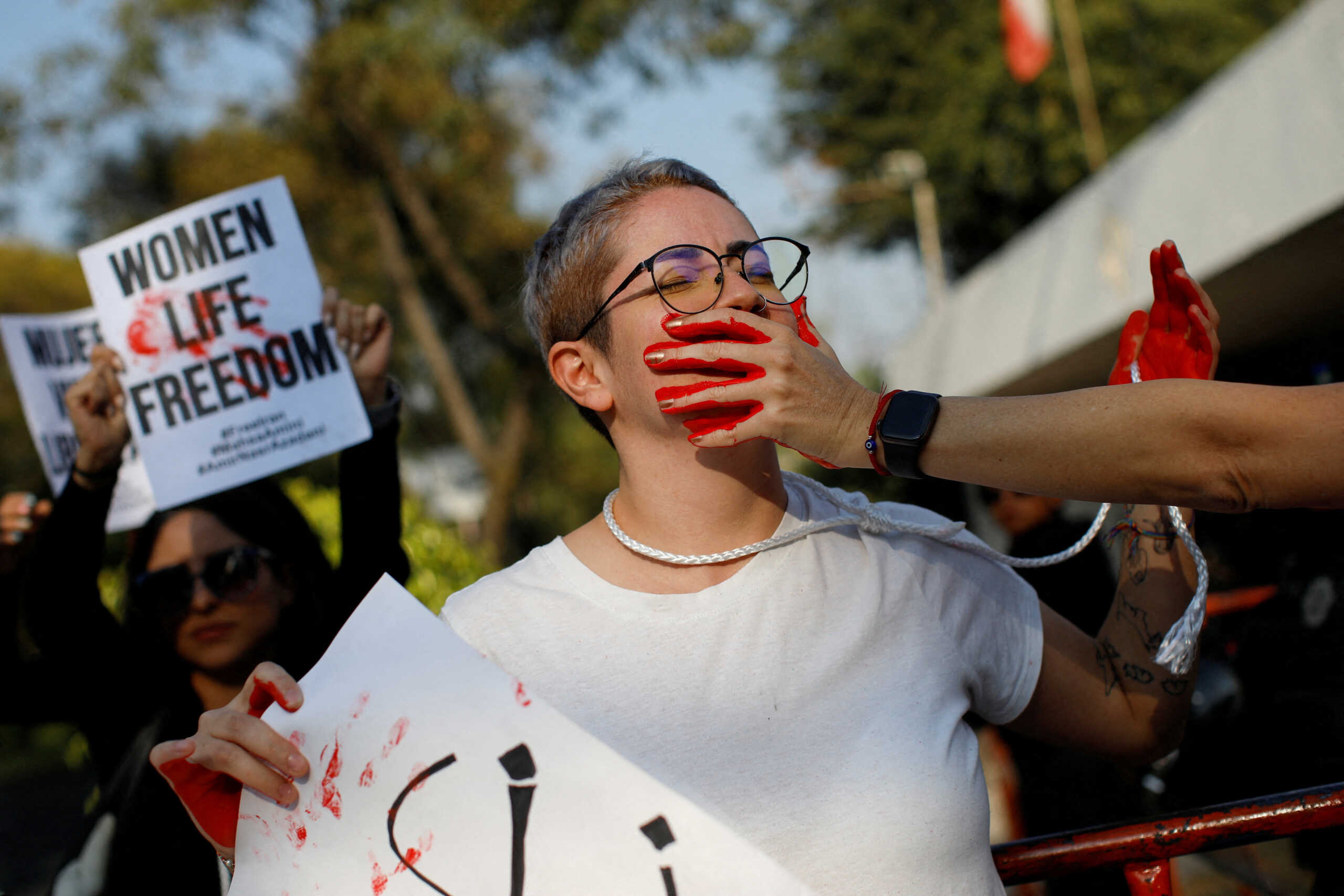 A woman has her mouth painted in red during a protest against Iran's ruling theocracy following the death of young Kurdish Iranian woman Mahsa Amini demanding authorities to free thousands of detained protesters and to stop executions, outside Iran's embassy, in Mexico City, Mexico December 19, 2022. REUTERS