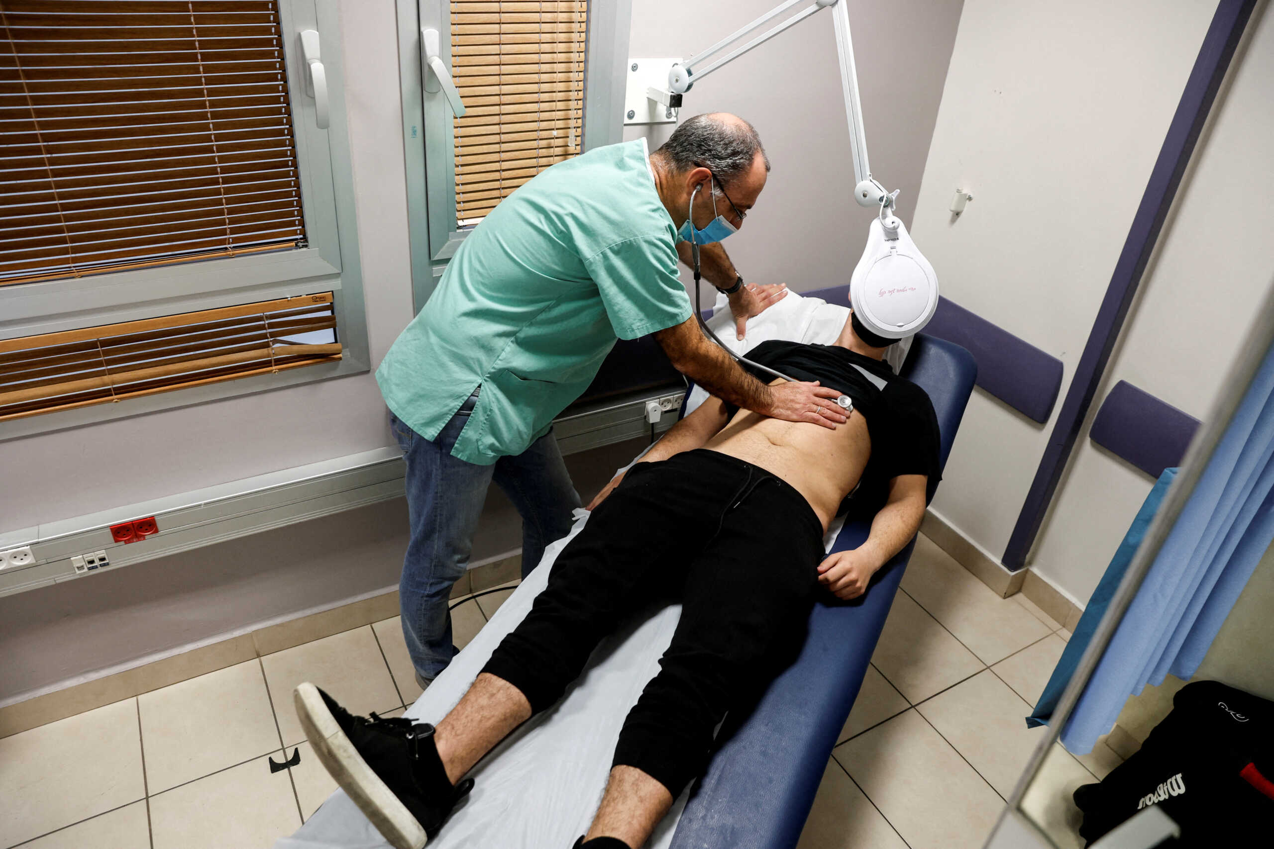 FILE PHOTO: A patient suffering from Long COVID is examined in the post-coronavirus disease (COVID-19) clinic of Ichilov Hospital in Tel Aviv, Israel, February 21, 2022. Picture taken February 21, 2022. REUTERS