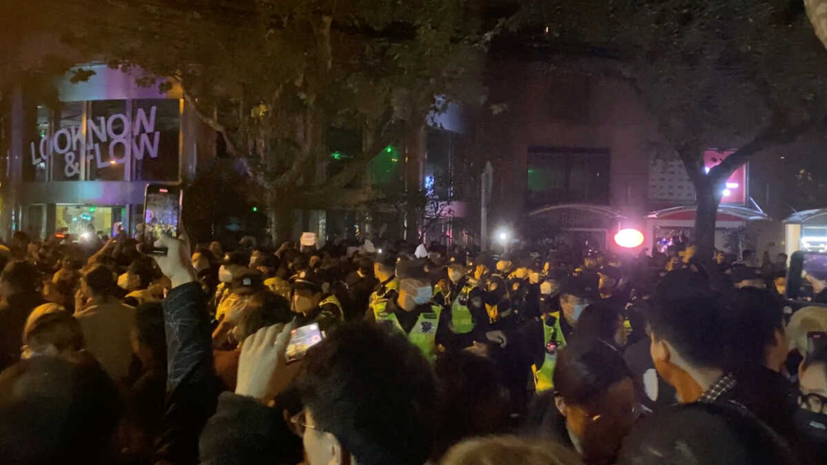 Police officers drive people away during a protest against coronavirus disease (COVID-19) curbs in Shanghai, China, November 27, 2022, in this screen grab obtained from a social media video. Eva Rammeloo