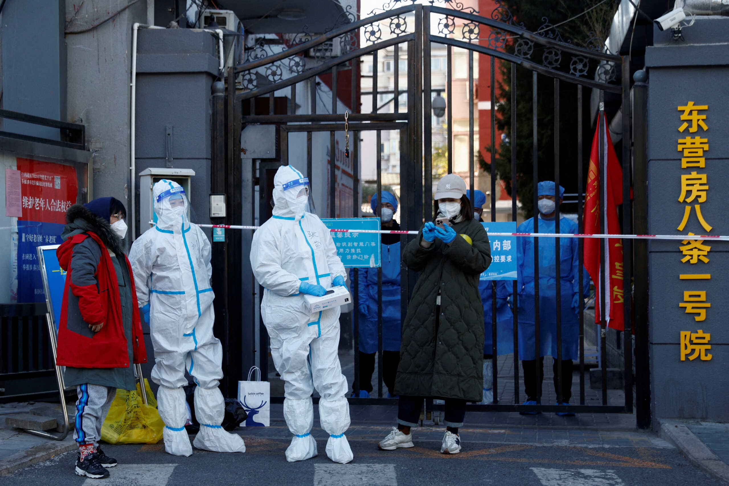 FILE PHOTO: Security personnel in protective suits stand at the gate of a residential compound that is under lockdown as outbreaks of coronavirus disease (COVID-19) continue in Beijing, October 22, 2022. REUTERS