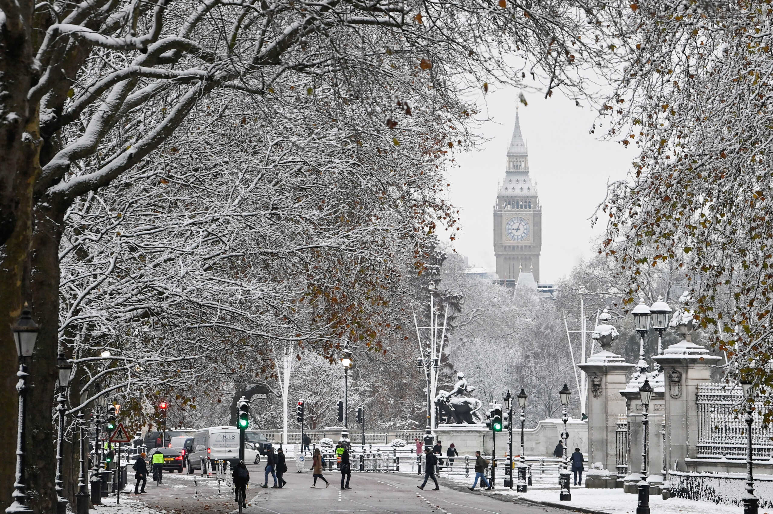People walk on the street in front of The Elizabeth Tower, more commonly known as Big Ben, as cold weather continues, in London, Britain, December 12, 2022. REUTERS