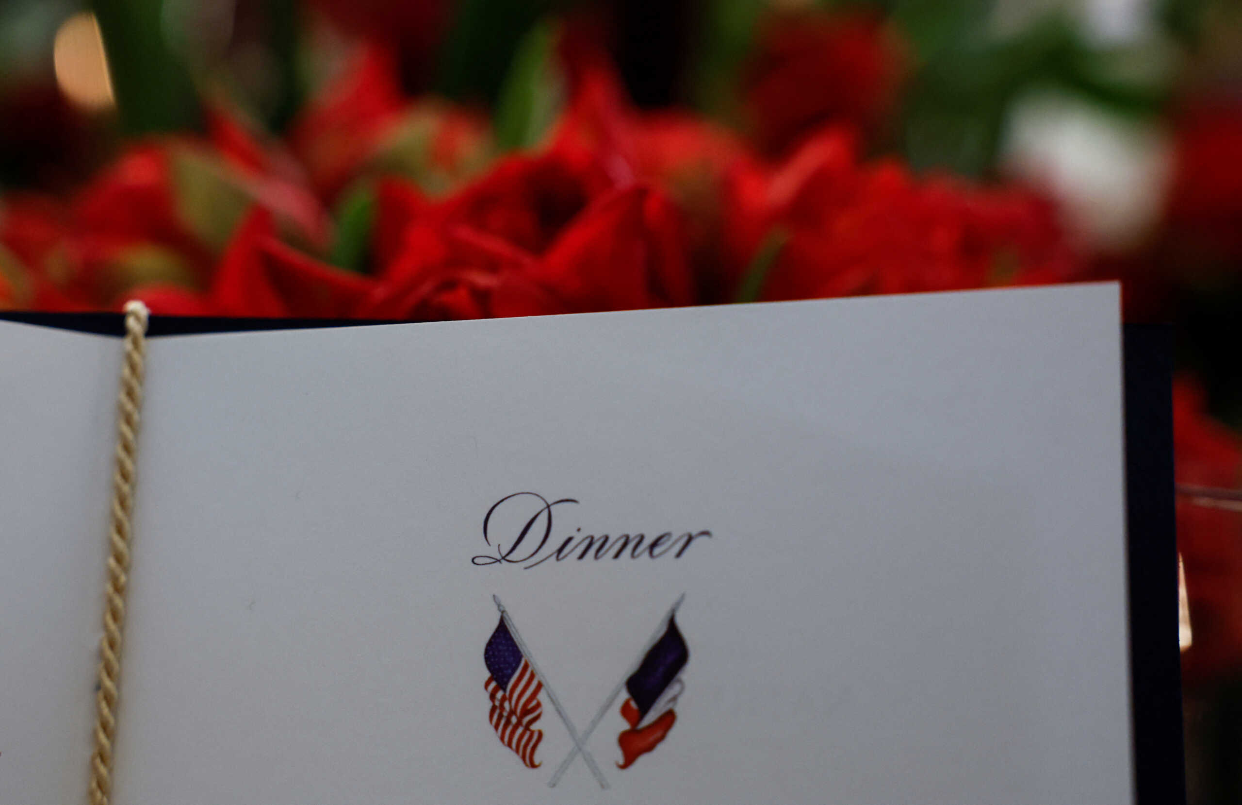 The dinner program and a floral arrangement are seen seen during a media preview in advance of Thursday evening's State Dnner in honor of French President Emmanuel Macron and his wife Brigitte Macron, at the White House in Washington, U.S., November 30, 2022. REUTERS