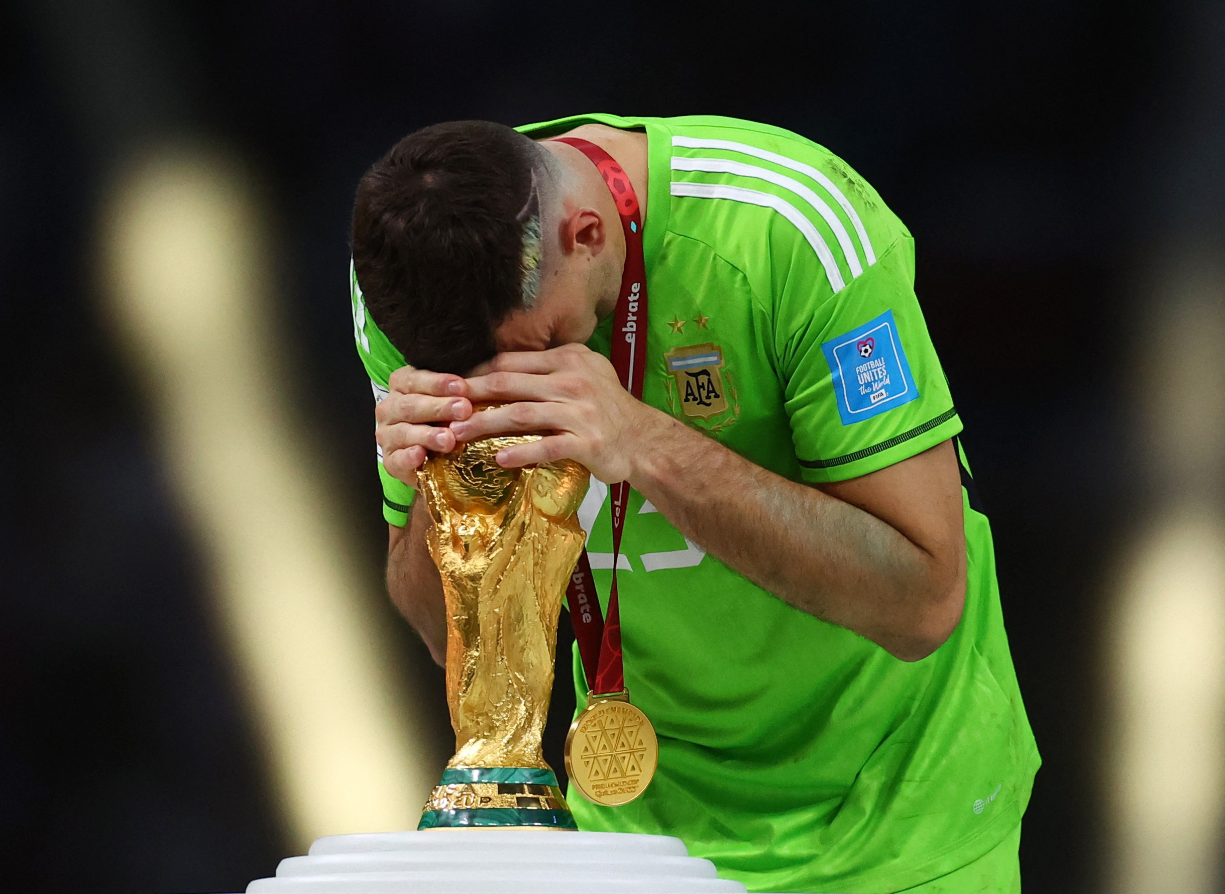 Soccer Football - FIFA World Cup Qatar 2022 - Final - Argentina v France - Lusail Stadium, Lusail, Qatar - December 18, 2022 Argentina's Emiliano Martinez touches the trophy during the trophy ceremony REUTERS