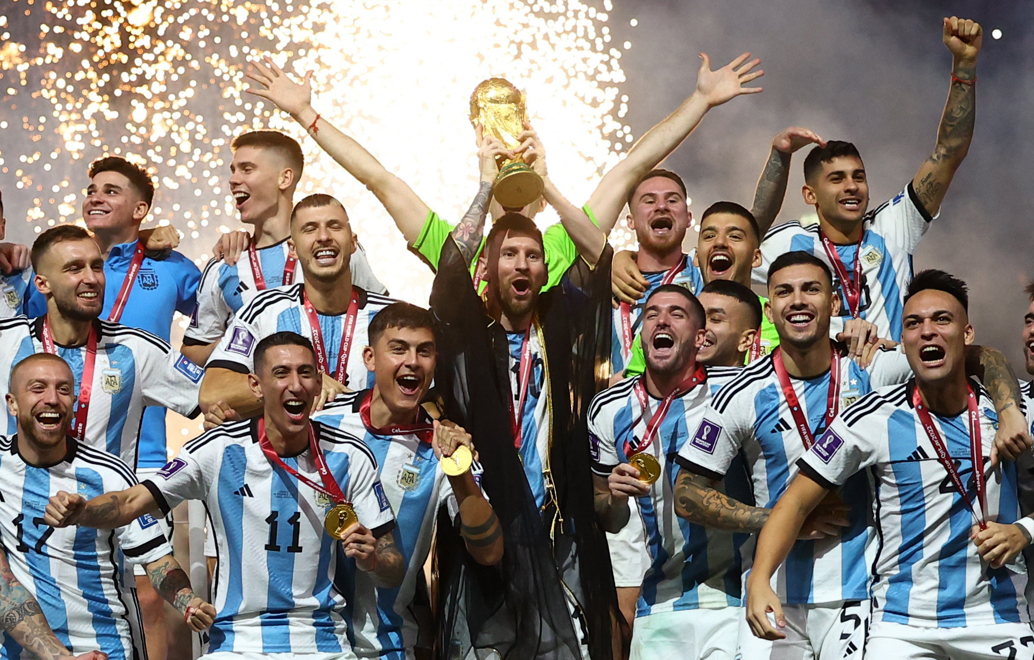 Soccer Football - FIFA World Cup Qatar 2022 - Final - Argentina v France - Lusail Stadium, Lusail, Qatar - December 18, 2022 Argentina's Lionel Messi lifts the World Cup trophy alongside teammates as they celebrate after winning the World Cup REUTERS
