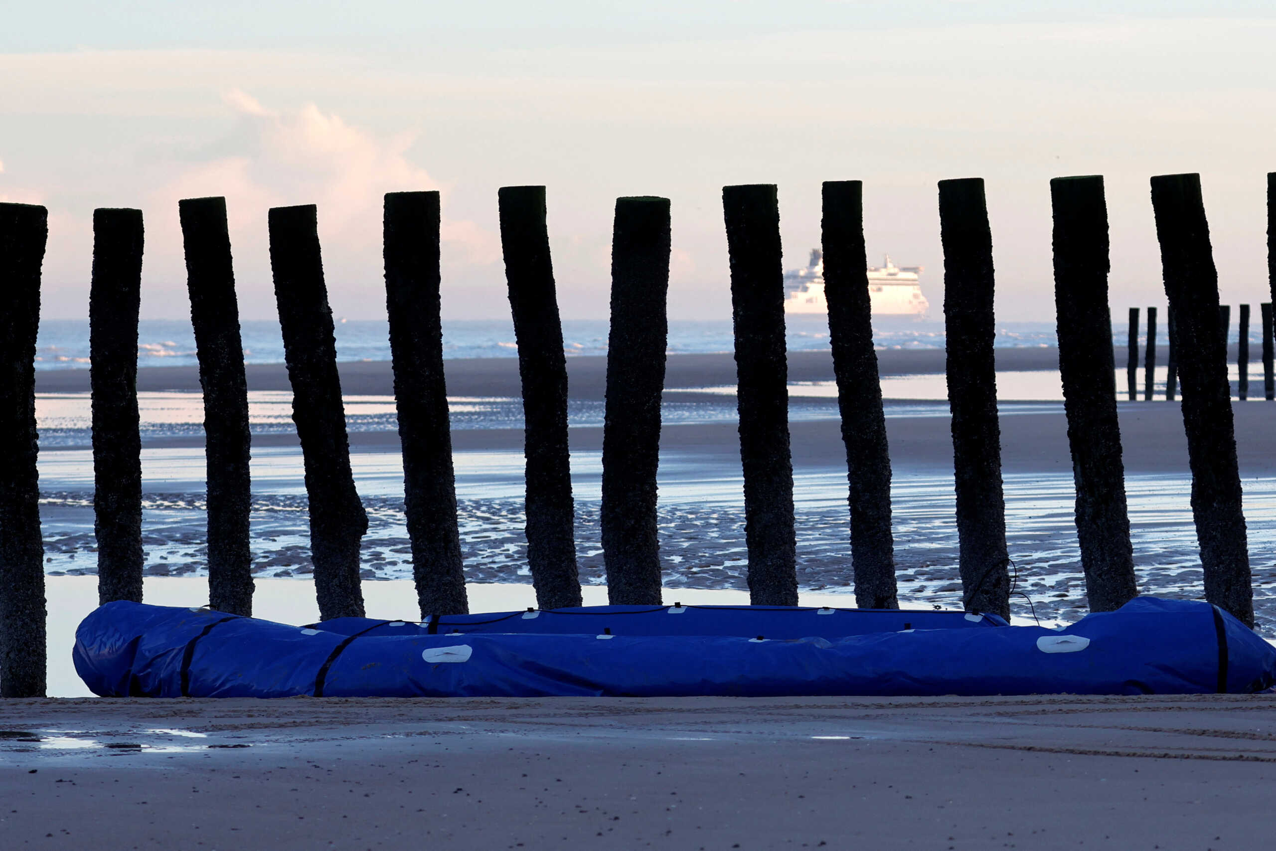 A damaged inflatable dinghy lies on the beach after a group of migrants traveled on it to leave the coast of northern France and to cross the English Channel, in Sangatte near Calais, northern France, November 29, 2022. REUTERS