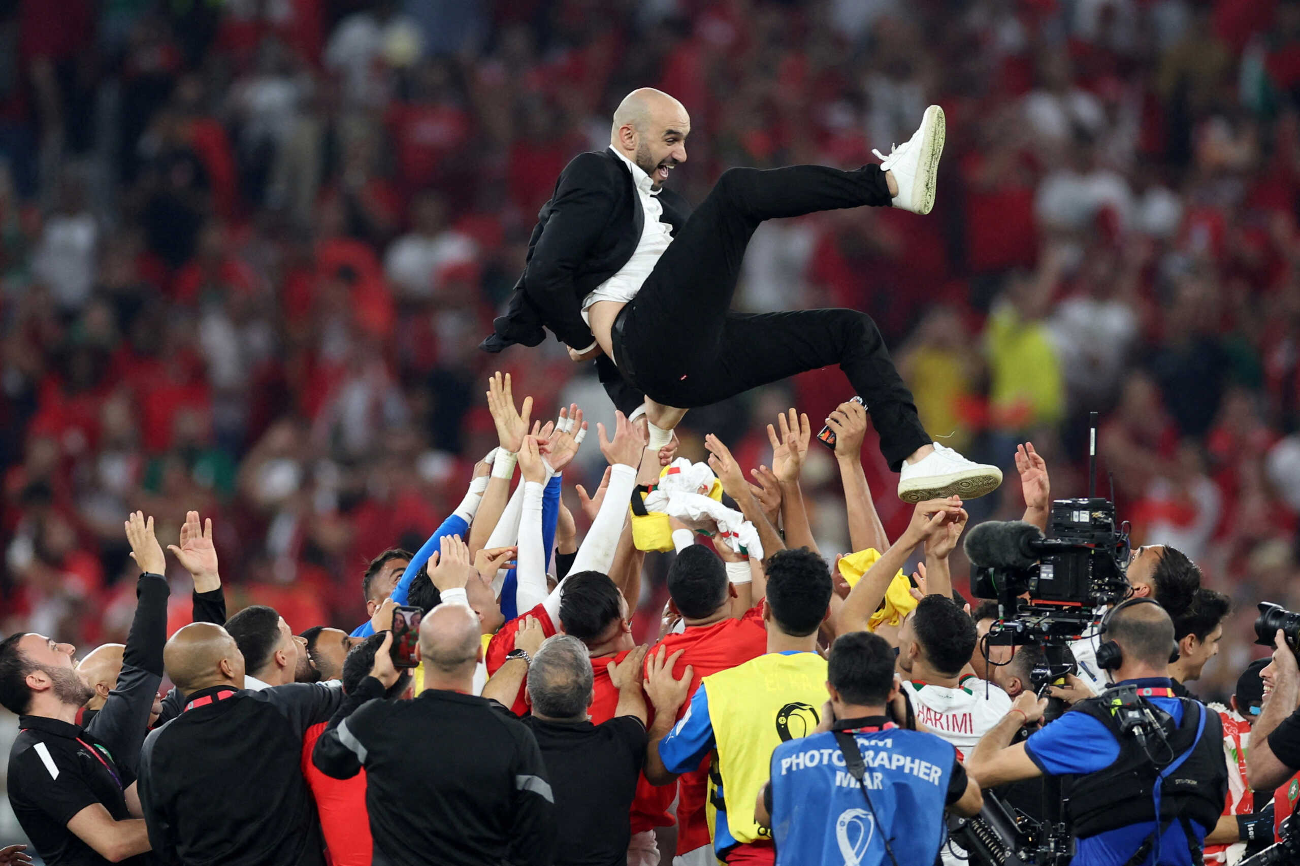 Soccer Football - FIFA World Cup Qatar 2022 - Group F - Canada v Morocco - Al Thumama Stadium, Doha, Qatar - December 1, 2022 Morocco coach Walid Regragui is thrown into the air by Morocco players as they celebrate qualifying for the knockout stages REUTERS