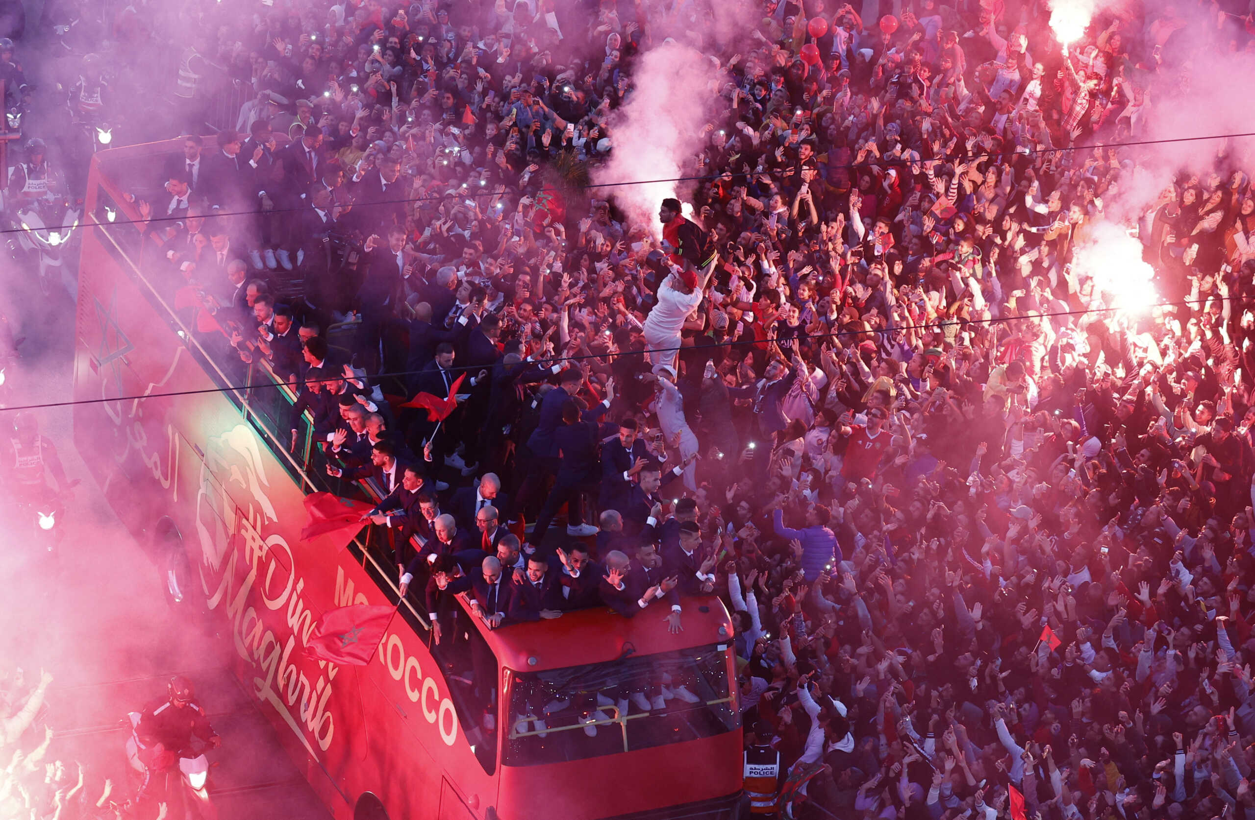 Soccer Football - FIFA World Cup Qatar 2022 - Morocco return after the World Cup - Rabat, Morocco - December 20, 2022 Morocco players are pictured on the bus as Morocco fans celebrate with flares during the bus parade REUTERS