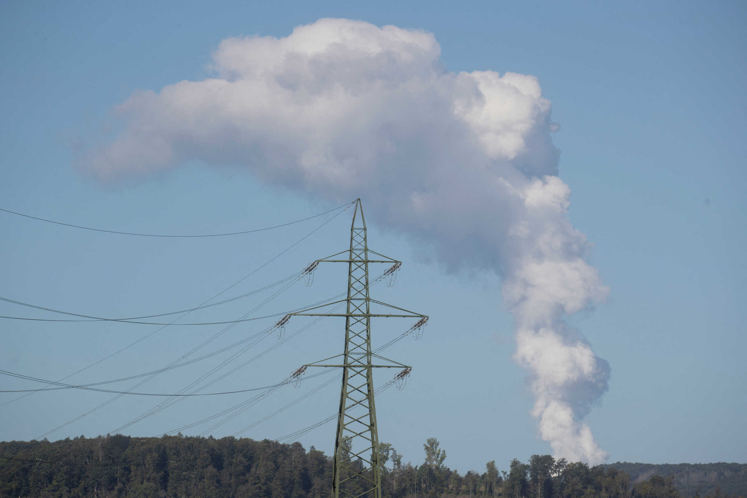 FILE PHOTO: A power pole is seen in front as steam rises from the cooling tower of the nuclear power plant KKW Leibstadt of Swiss energy company Kernkraftwerk Leibstadt AG near Weiach, Switzerland September 20, 2022. REUTERS