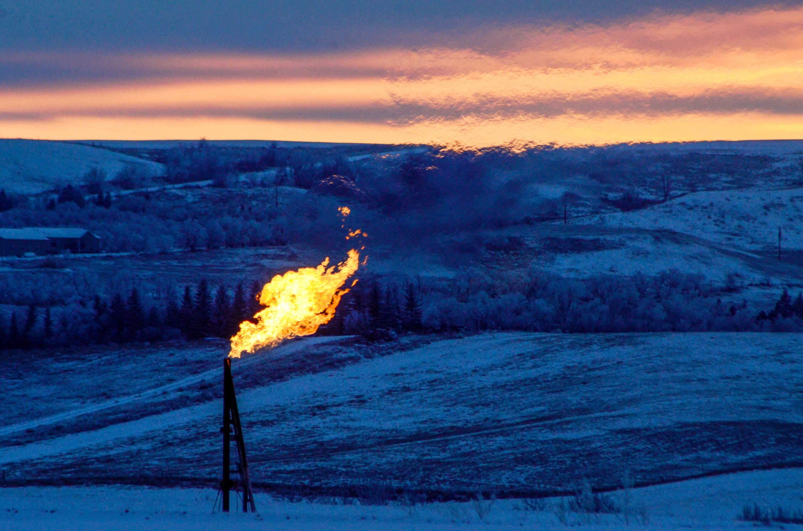 FILE PHOTO: A natural gas flare on an oil well pad burns as the sun sets outside Watford City, North Dakota January 21, 2016. REUTERS