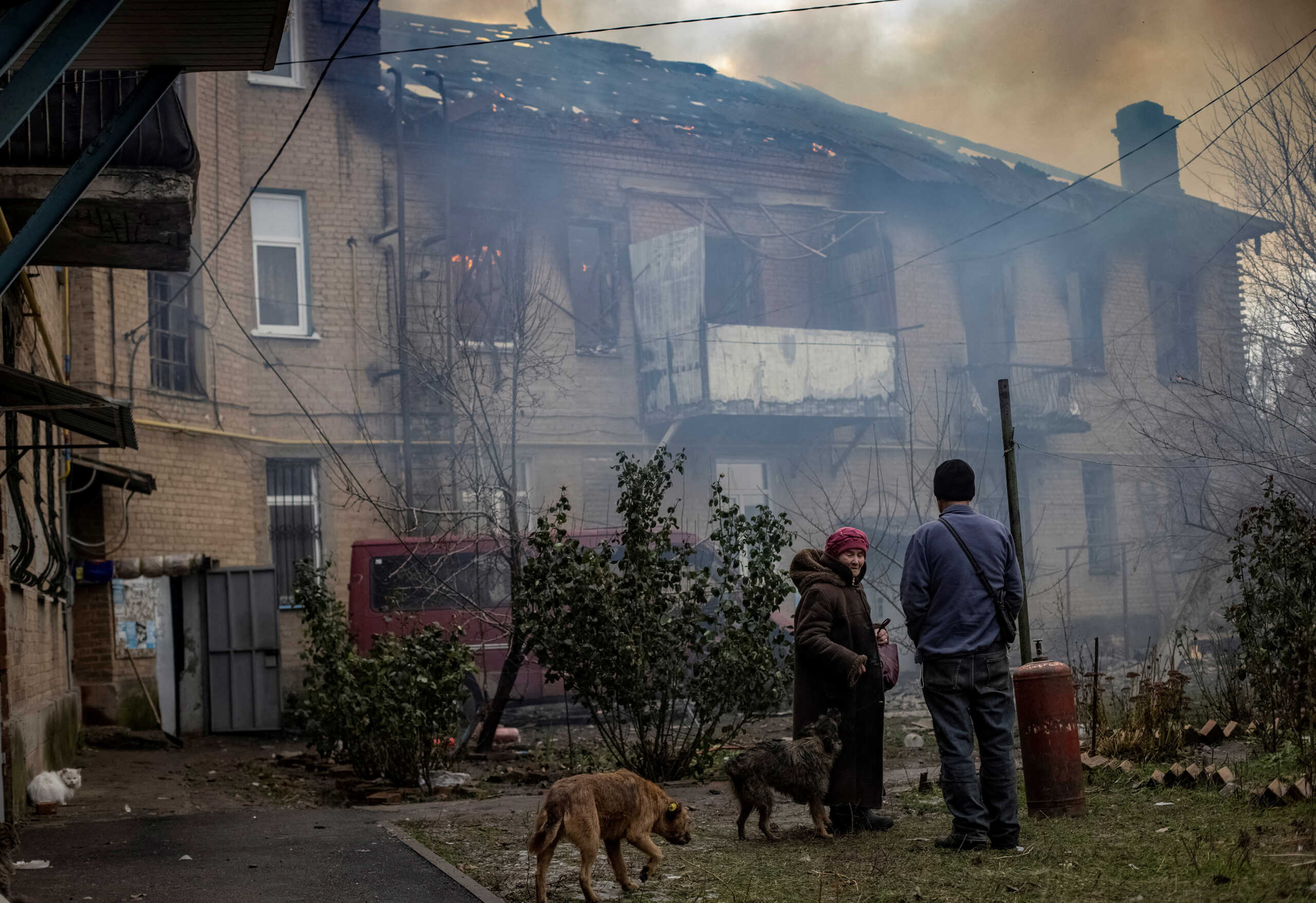 Local residents stand in the yard of their destroyed apartment building in Bakhmut, as Russia's attack on Ukraine continues, in Donetsk region, Ukraine December 9, 2022. REUTERS