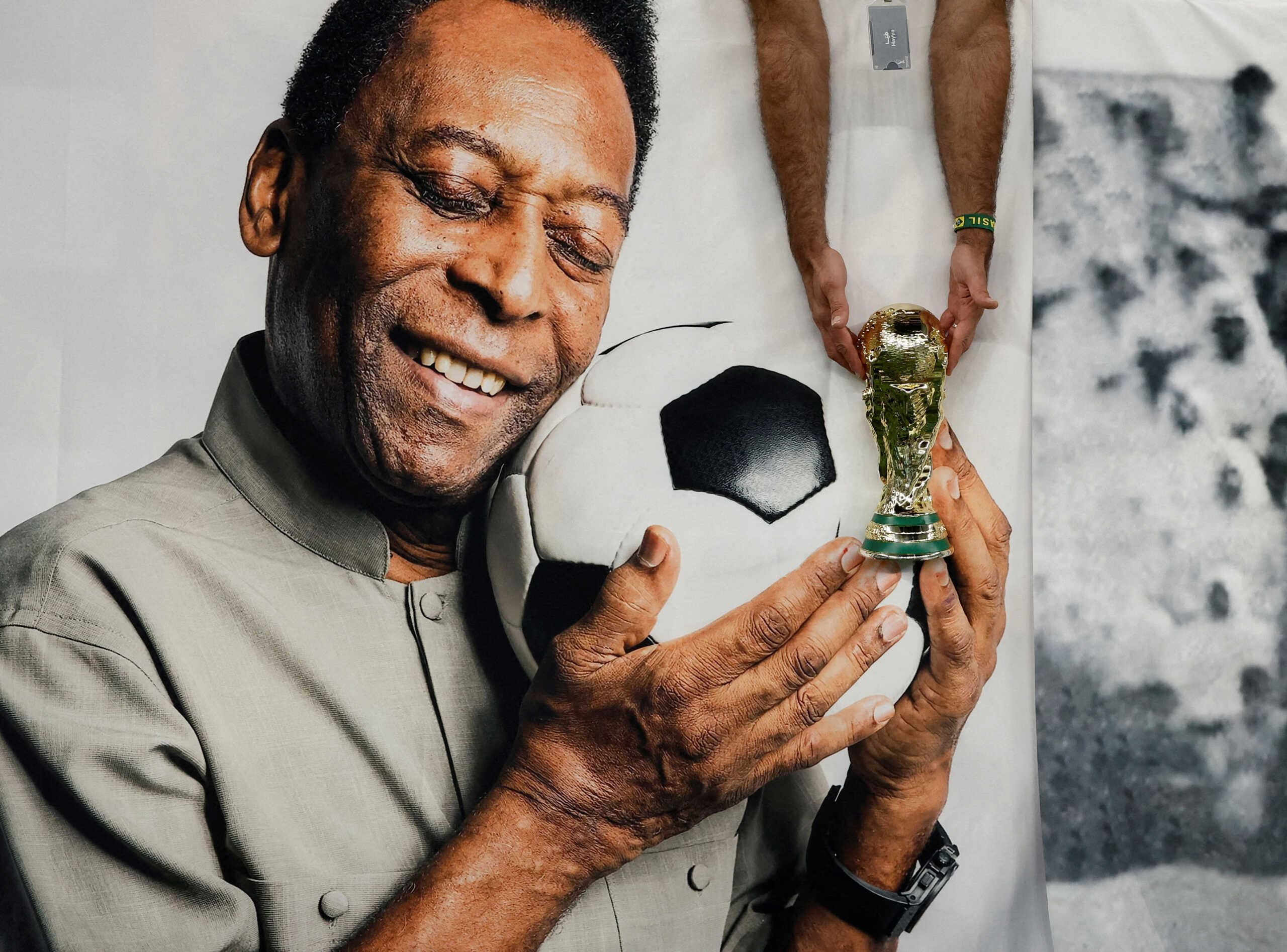 FILE PHOTO: Soccer Football - FIFA World Cup Qatar 2022 - Group G - Cameroon v Brazil - Lusail Stadium, Lusail, Qatar - December 2, 2022 Brazil fan holds a replica World Cup trophy in front of a banner of former Brazil player Pele inside the stadium before the match REUTERS