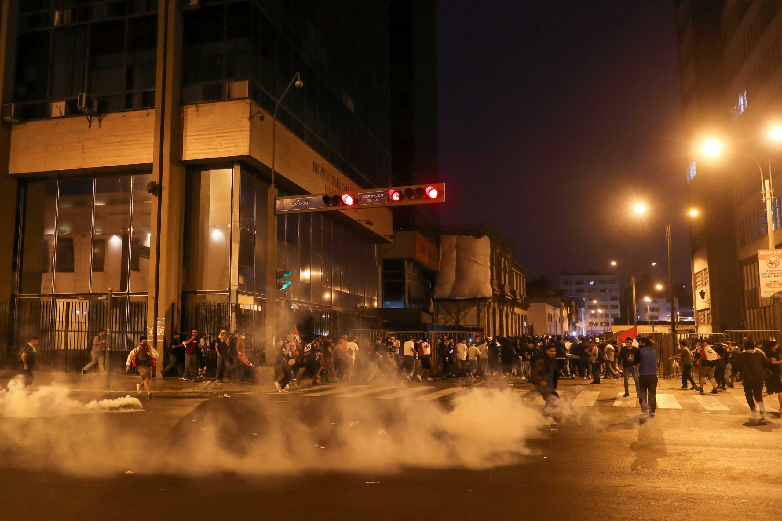 Demonstrators walk near tear gas during a protest demanding the dissolution of Congress and to hold democratic elections rather than recognize Dina Boluarte as Peru's President, after the ouster of Peruvian leader Pedro Castillo, in Lima, Peru December 11, 2022. REUTERS