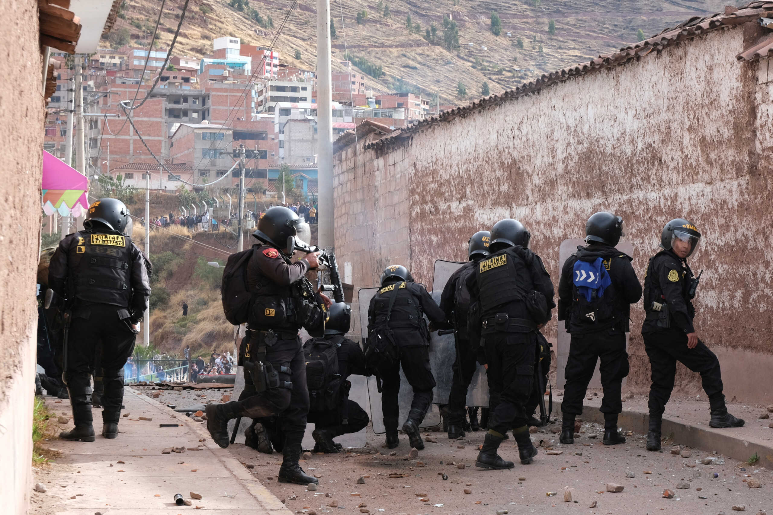 Police officers use their shields as people protest demanding the dissolution of the Congress and to hold democratic elections rather than recognizing Dina Boluarte as Peru's President, after the ouster of Peruvian President Pedro Castillo, in Cuzco, Peru December 14, 2022. REUTERS