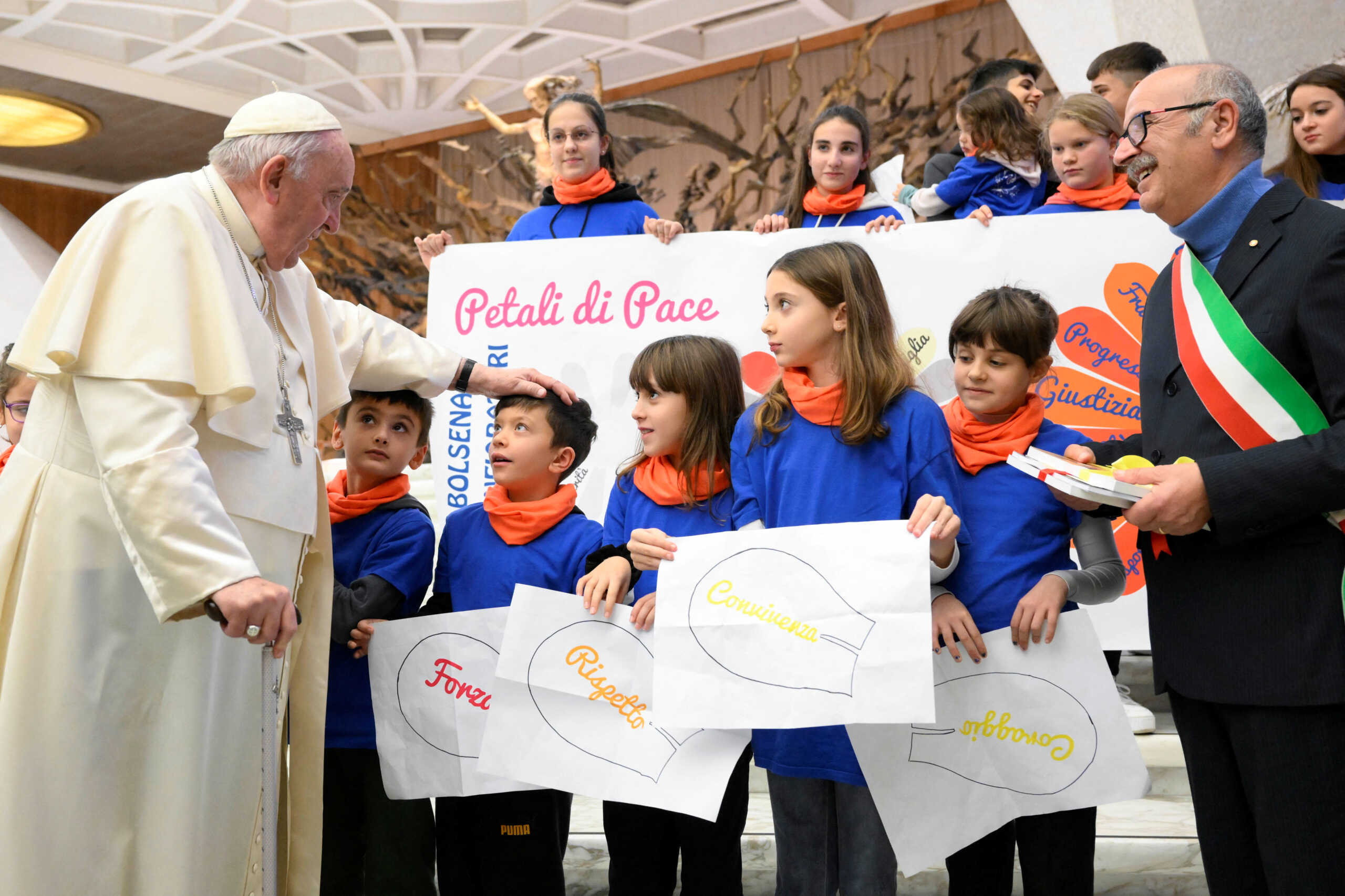 Pope Francis greets children as he attends the weekly general audience at the Vatican, December 21, 2022.   Vatican Media