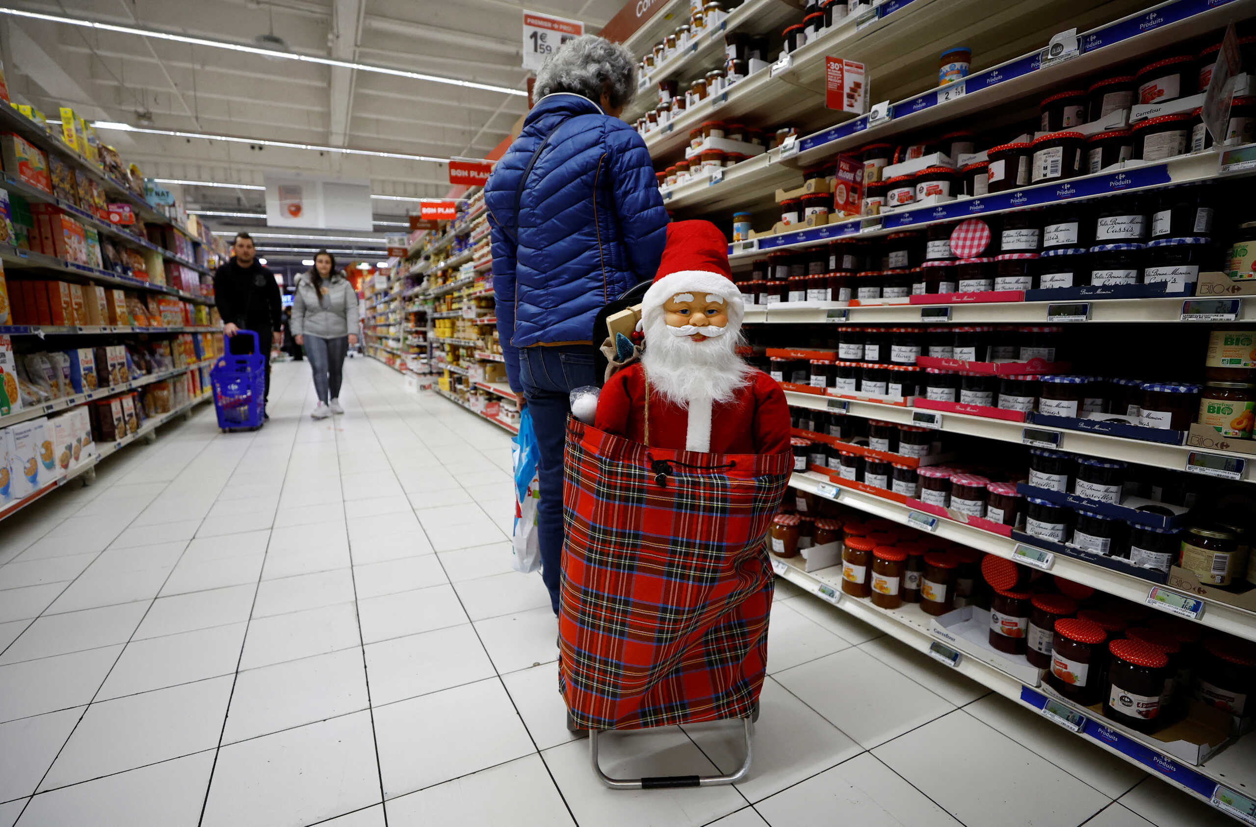 A Santa Claus figurine is seen in a shopping trolley as a customer shops in a supermarket in Nice, France, November 30, 2022.  REUTERS