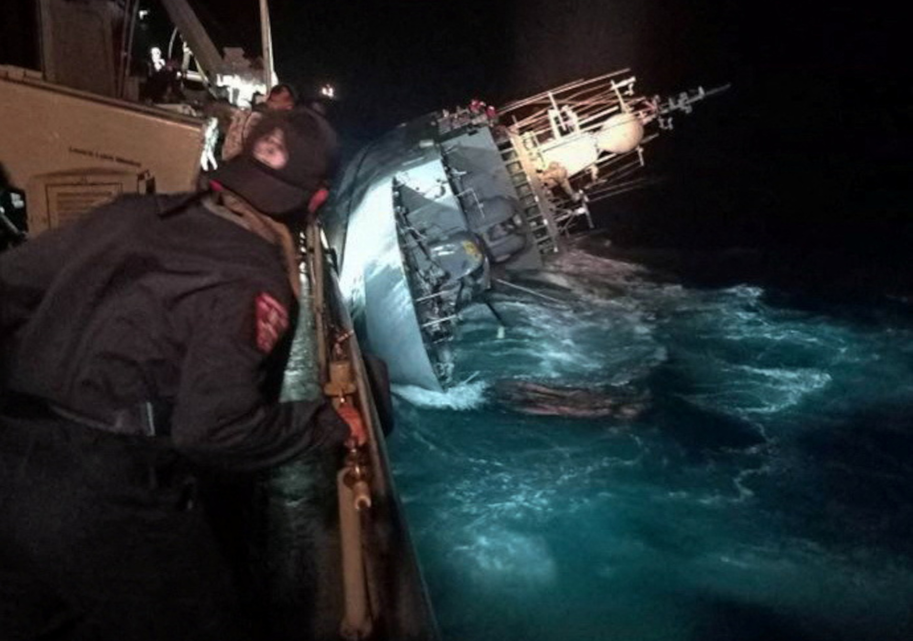 A marine looks at the capsized HTMS Sukhothai warship in the Gulf of Thailand, December 18, 2022. Royal Thai Navy Handout via REUTERS THIS IMAGE HAS BEEN SUPPLIED BY A THIRD PARTY. MANDATORY CREDIT. NO RESALES. NO ARCHIVES