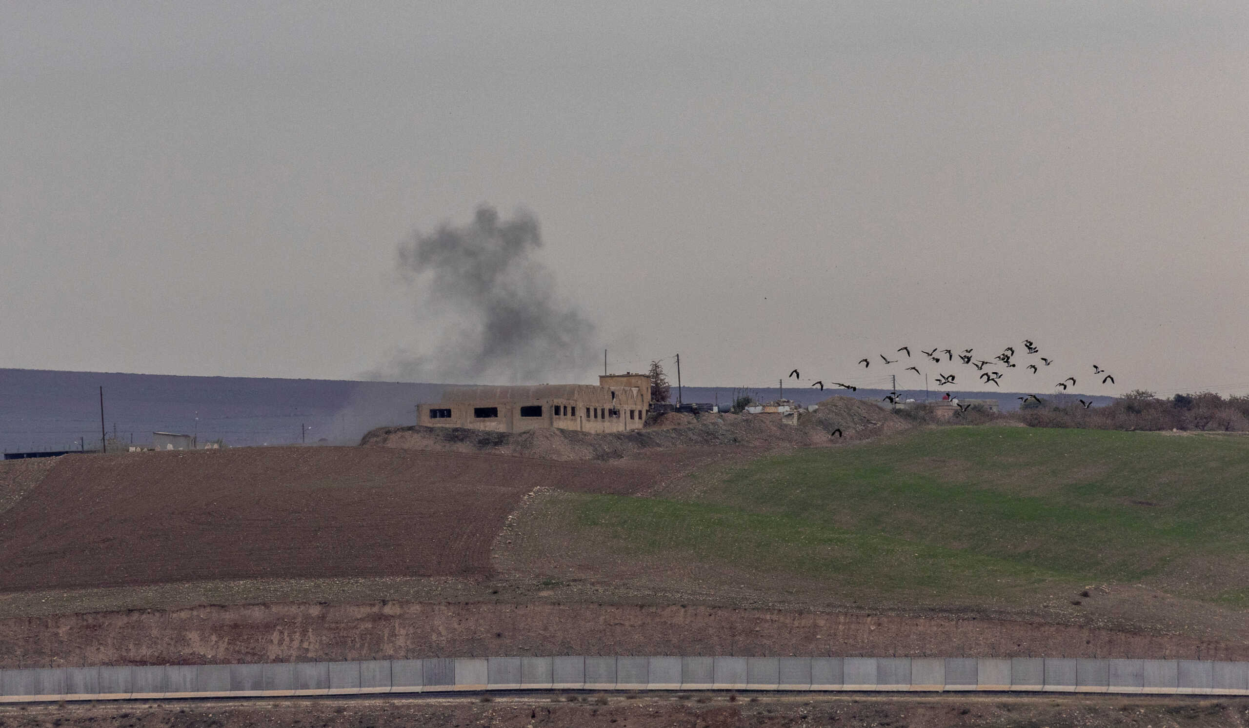 Smoke rises from a building after a shelling hit targets near the northern Syrian village of Zor Magar, as seen from the Turkish border town of Karkamis in Gaziantep province, Turkey, November 29, 2022. REUTERS
