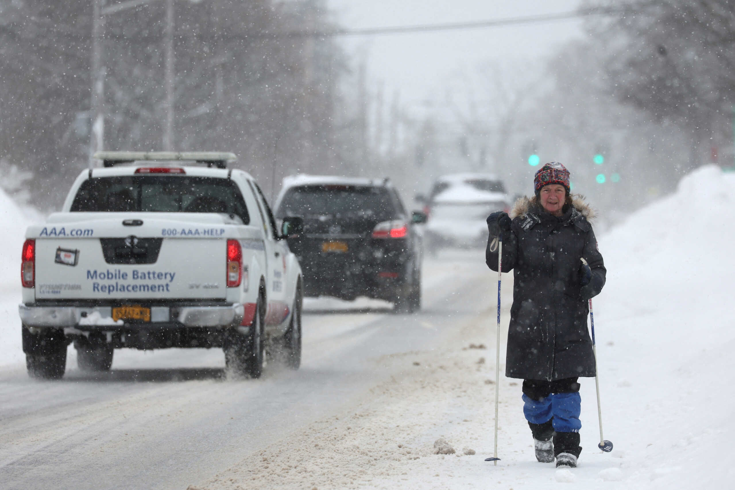 A woman walks the street as cars pass by following a winter storm that hit the Buffalo region, in Amherst, New York, U.S., December 26, 2022.  REUTERS