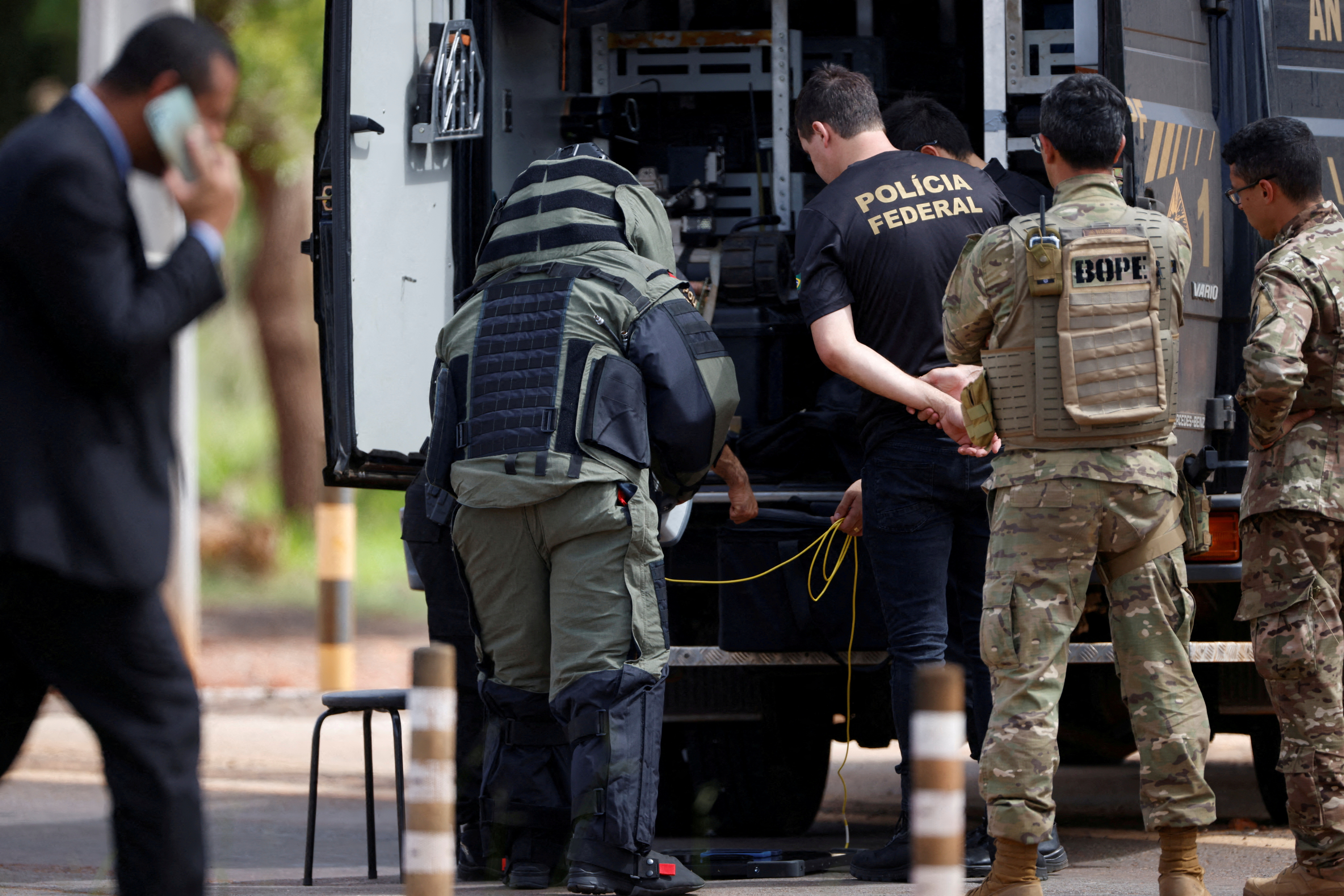 Security forces work as a robot of the federal police bomb squad is seen near what is believed to be an explosive artifact in Brasilia, Brazil, December 24, 2022. REUTERS