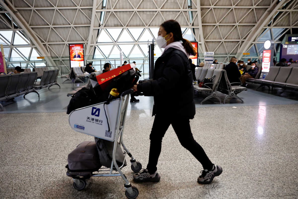A traveller pushes a luggage cart at Chengdu Shuangliu International Airport amid a wave of the coronavirus disease (COVID-19) infections, in Chengdu, Sichuan province, China December 30, 2022. REUTERS