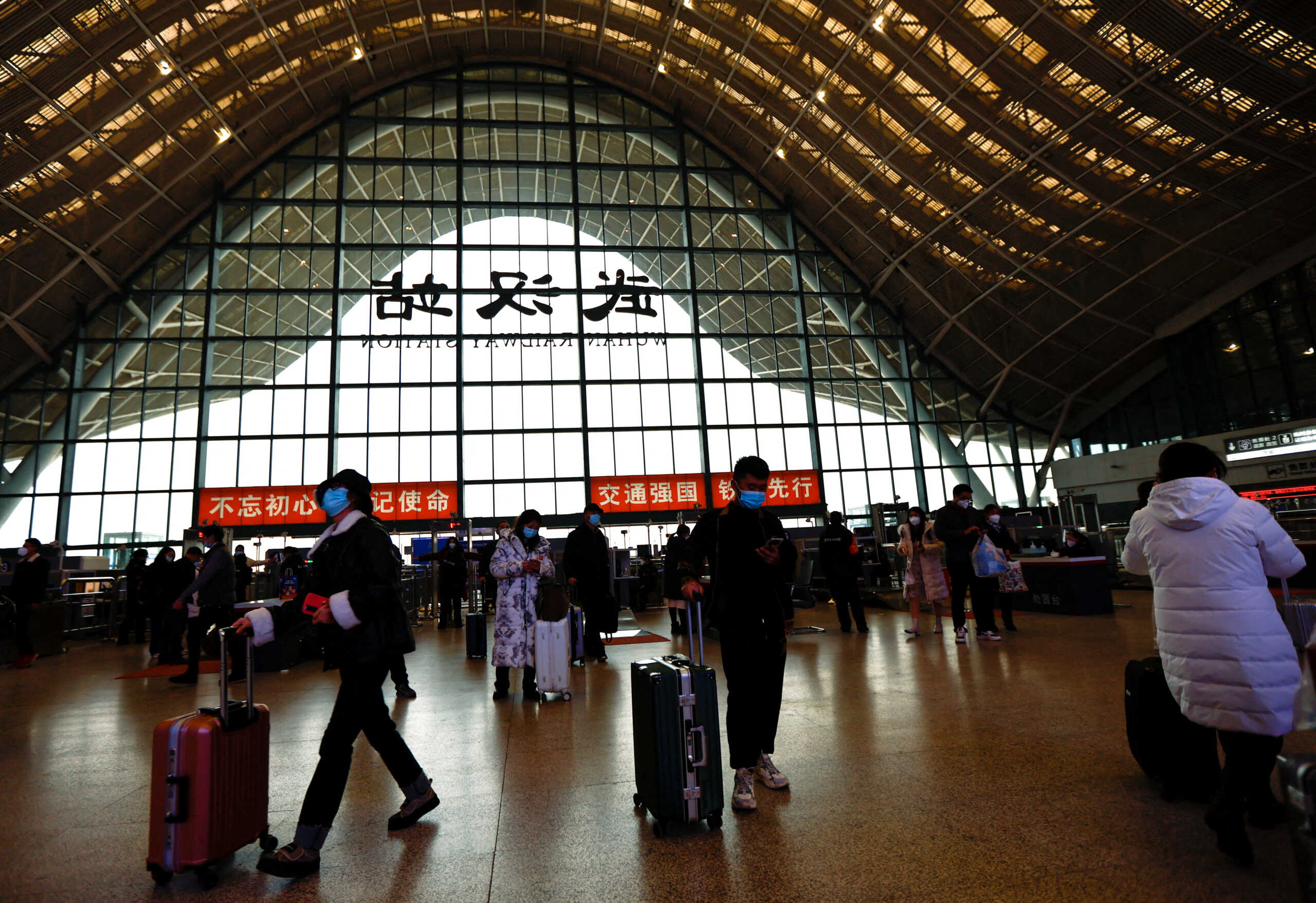 FILE PHOTO: People wait with luggages at a railway station, amid the coronavirus disease (COVID-19) outbreak, in Wuhan, Hubei province, China January 1, 2023. REUTERS