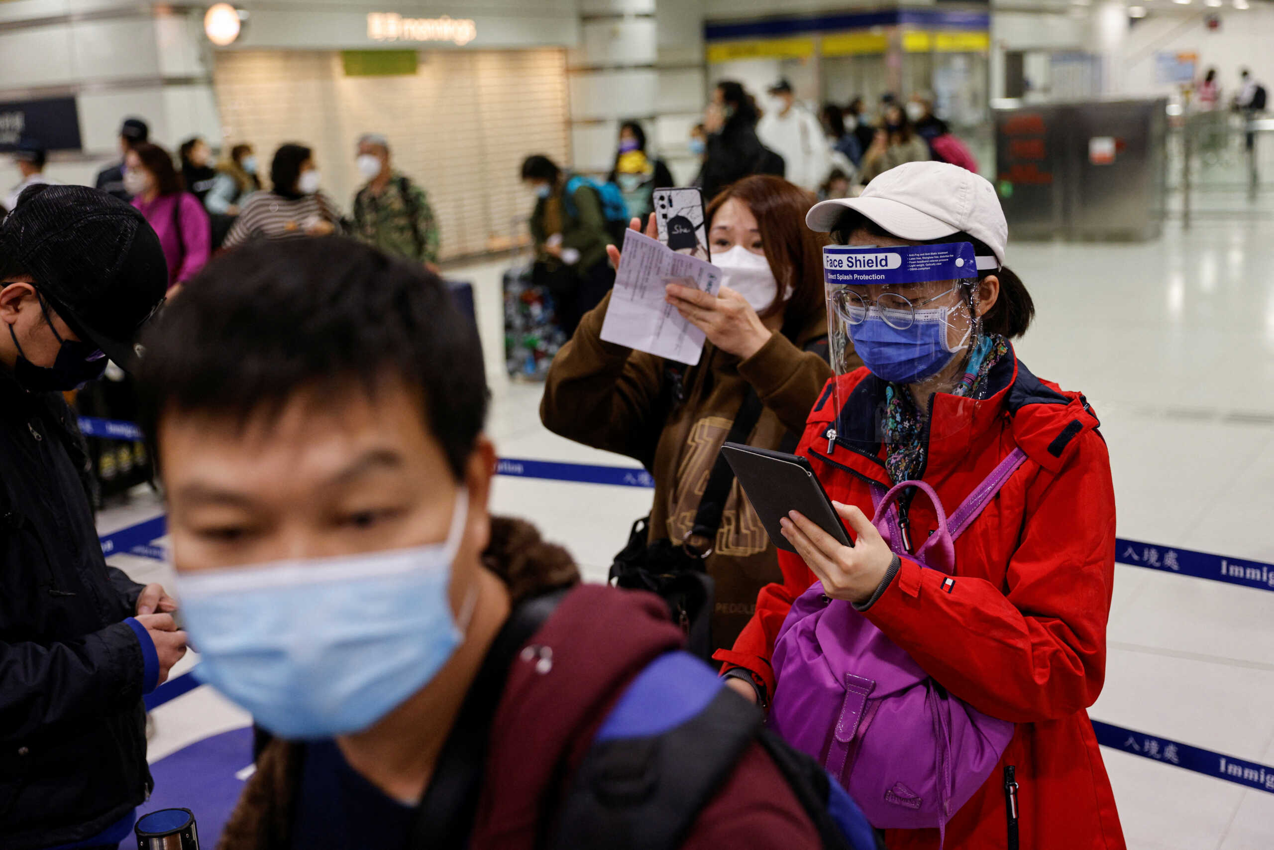 A traveller wearing a face mask and a face shield stands at Hong Kong's Lok Ma Chau border checkpoint on the first day China reopens the border amid the coronavirus disease (COVID-19) pandemic in Hong Kong, China, January 8, 2023. REUTERS