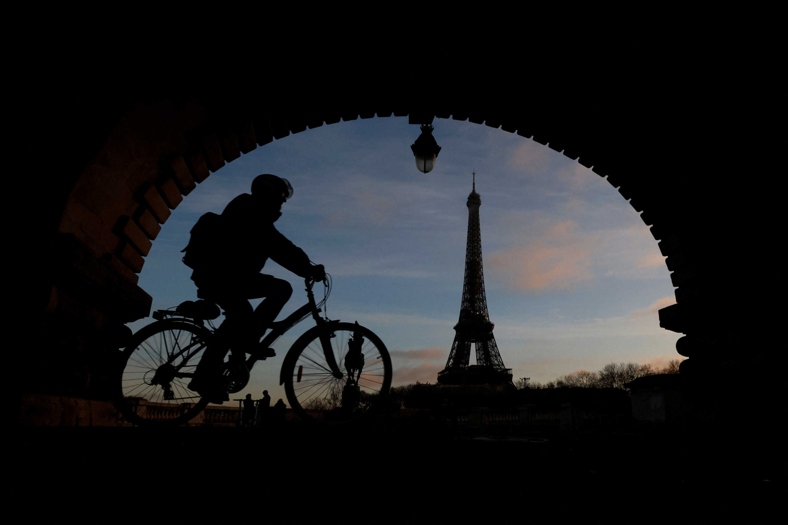 A man rides a bicycle along a bike path on the Pont de Bir-Hakeim bridge near the Eiffel Tower in Paris during a nationwide day of strike and protests against the French government's pension reform plan in France, January 19, 2023. REUTERS