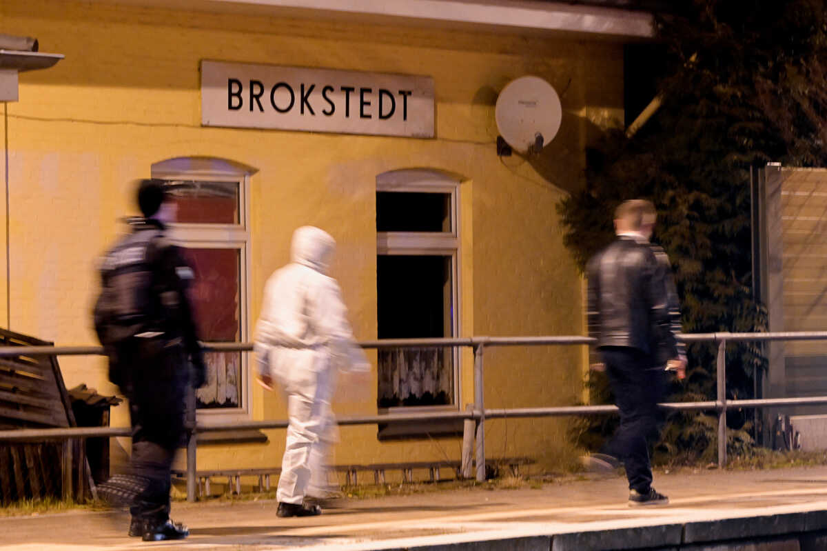 A forensic expert and a police officer walk at a railway station after an incident involving a knife attack took place on a train travelling between Kiel and Hamburg, in Brokstedt, Germany, January 25, 2023.   REUTERS