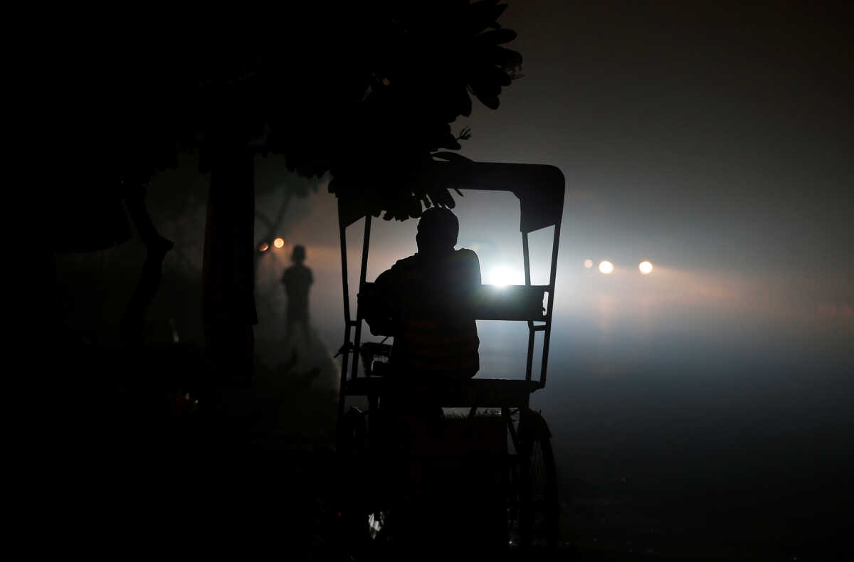 A rickshaw puller waits for customers along a roadside amidst heavy smog in New Delhi, India November 6, 2016. REUTERS