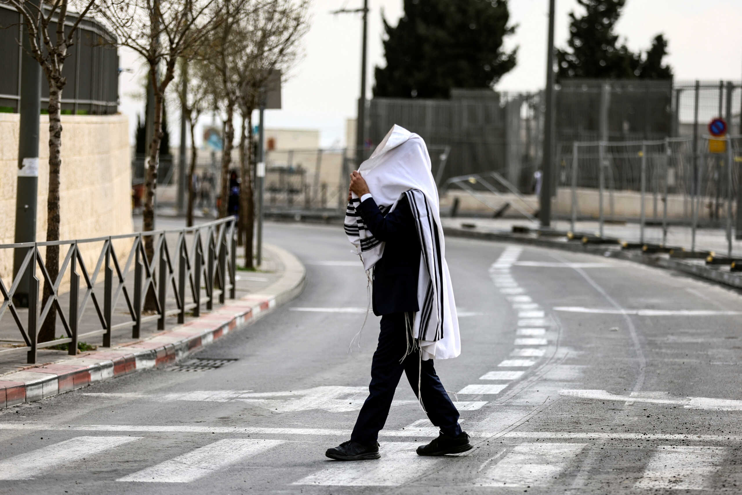 An Israeli man crosses a street near the scene of a shooting attack that happened the night before, in Neve Yaacov which lies on occupied land that Israel annexed to?Jerusalem?after the 1967 Middle East war, January 28, 2023. REUTERS