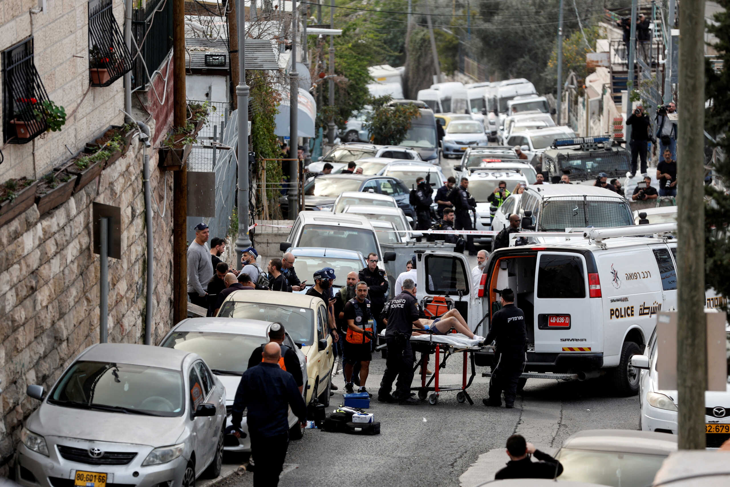 A person is wheeled on a stretcher at a scene where a suspected incident of shooting attack took place, police spokesman said, just outside Jerusalem's Old City January 28, 2023. REUTERS
