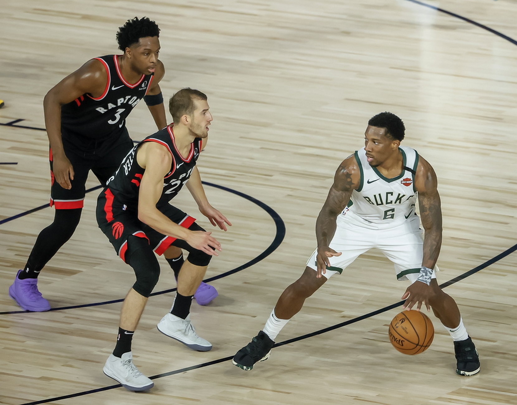 epa08596599 Milwaukee Bucks guard Eric Bledsoe (R) in action against Toronto Raptors guard Matt Thomas (C) and Toronto Raptors forward OG Anunoby of Britain (L) during the second half of the NBA basketball game between the Toronto Raptors and the Milwaukee Bucks at the ESPN Wide World of Sports Complex in Kissimmee, Florida, USA, 10 August 2020.  EPA