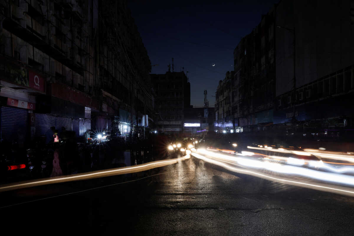 Vehicle lights cause light streaks on the road along a market, during country-wide power breakdown in Karachi, Pakistan January 23, 2023. REUTERS