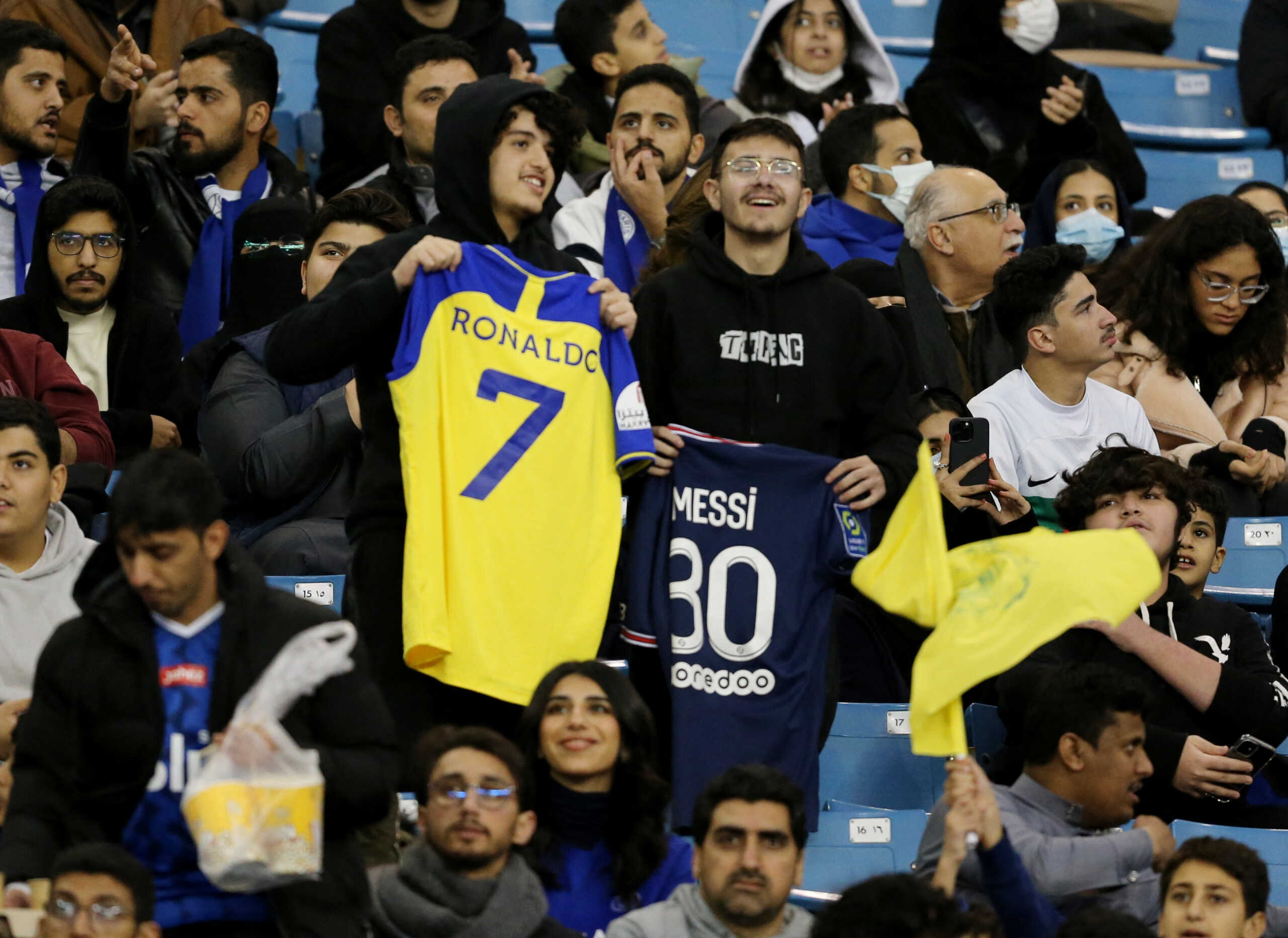 Soccer Football - Friendly - Saudi Pro League XI v Paris St Germain - King Fahd International Stadium, Riyadh, Saudia Arabia - January 19, 2023 Fans hold up shirts with Al Nassr's Cristiano Ronaldo's and Paris St Germain's Lionel Messi's name on inside the stadium before the match REUTERS