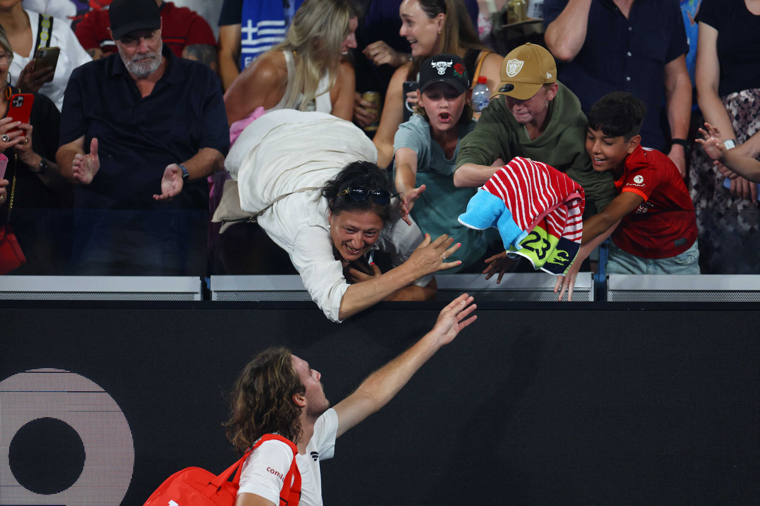 Tennis - Australian Open - Melbourne Park, Melbourne, Australia - January 16, 2023 Greece's Stefanos Tsitsipas gives his towel to fans after winning his first round match against France's Quentin Halys REUTERS