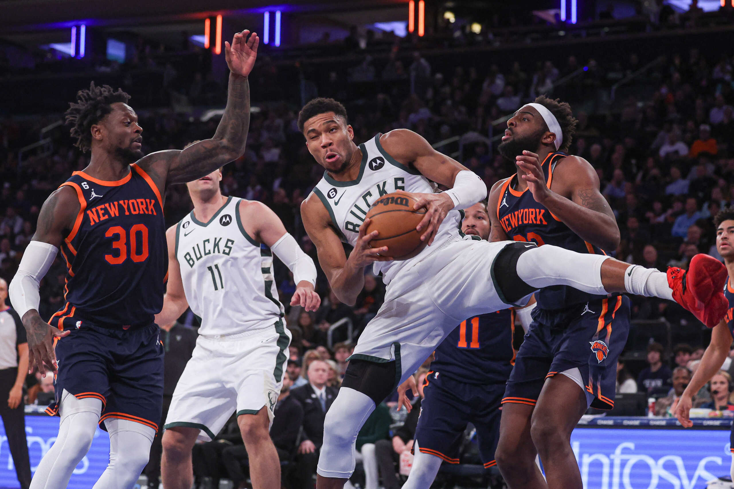 Jan 9, 2023; New York, New York, USA; Milwaukee Bucks forward Giannis Antetokounmpo (34) rebounds in front of New York Knicks center Mitchell Robinson (23) and forward Julius Randle (30) during the during the third quarter  at Madison Square Garden. Mandatory Credit: Vincent Carchietta-USA TODAY Sports