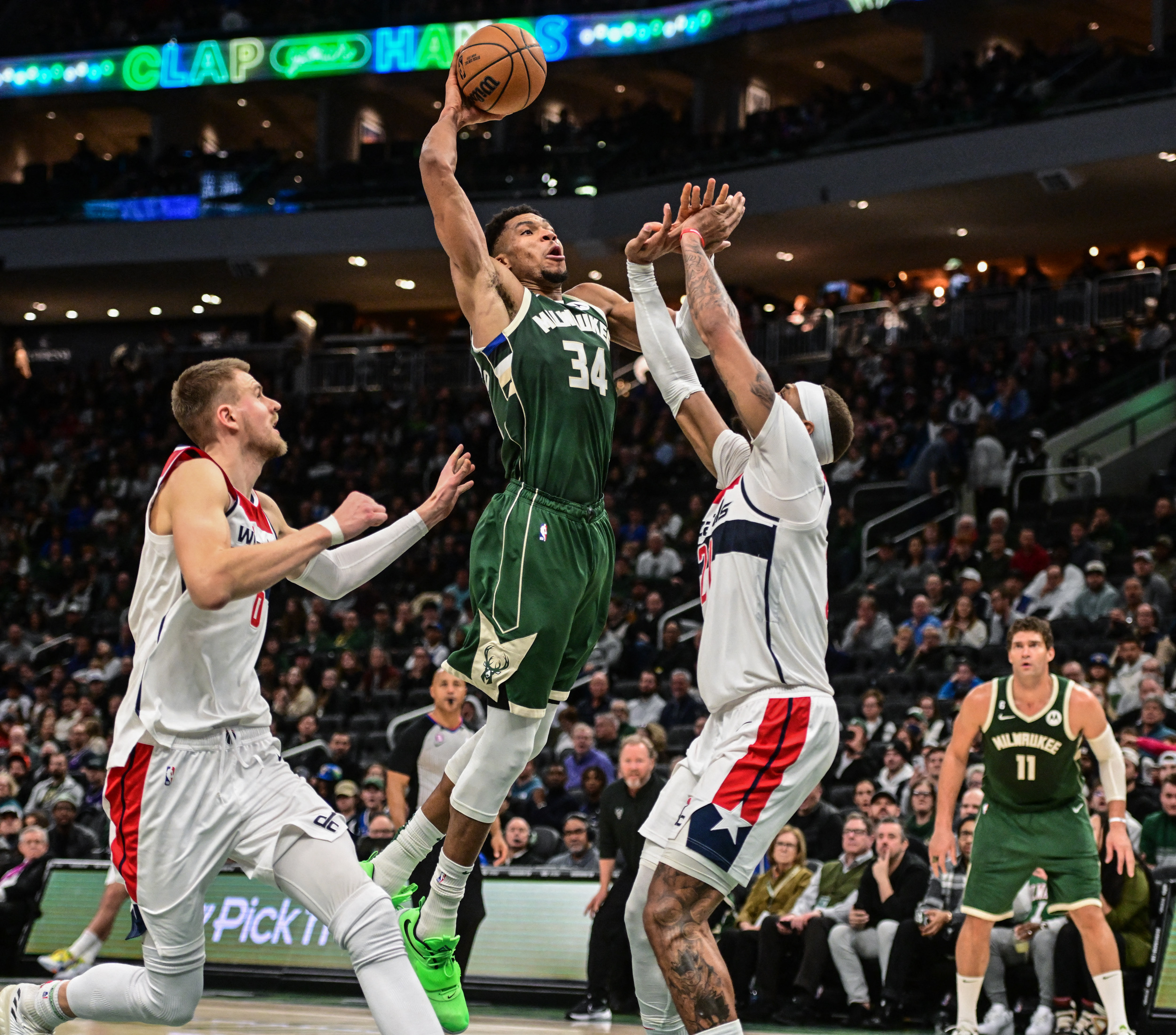 Jan 3, 2023; Milwaukee, Wisconsin, USA; Milwaukee Bucks forward Giannis Antetokounmpo (34) takes a shot between Washington Wizards forward Kristaps Porzingis (6) and center Daniel Gafford (21) in the fourth quarter at Fiserv Forum. Mandatory Credit: Benny Sieu-USA TODAY Sports