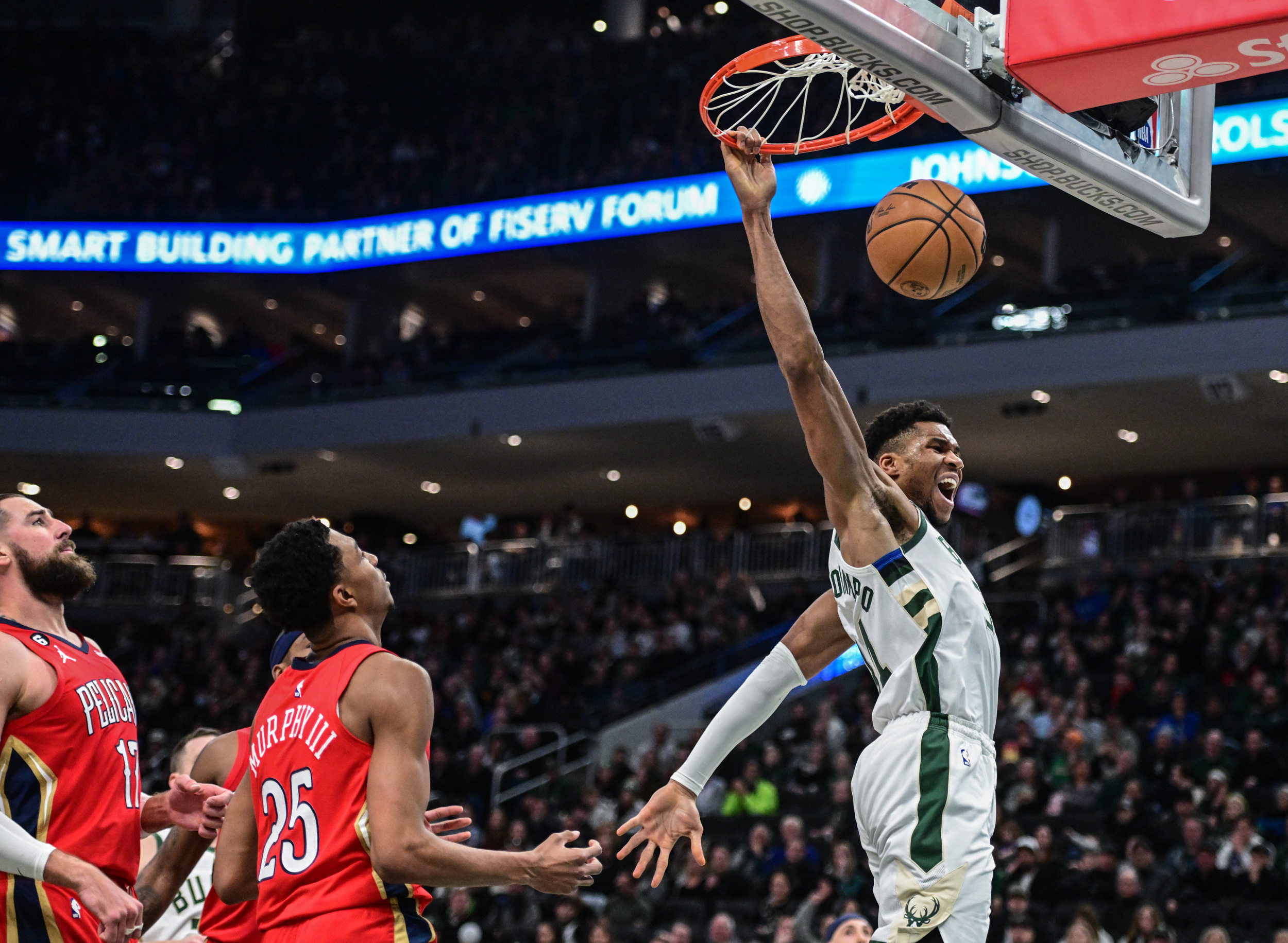 Jan 29, 2023; Milwaukee, Wisconsin, USA;  Milwaukee Bucks forward Giannis Antetokounmpo (34) reacts after dunking a basket in the third quarter against New Orleans Pelicans center Jonas Valanciunas (17) and forward Trey Murphy III (25) at Fiserv Forum. Mandatory Credit: Benny Sieu-USA TODAY Sports
