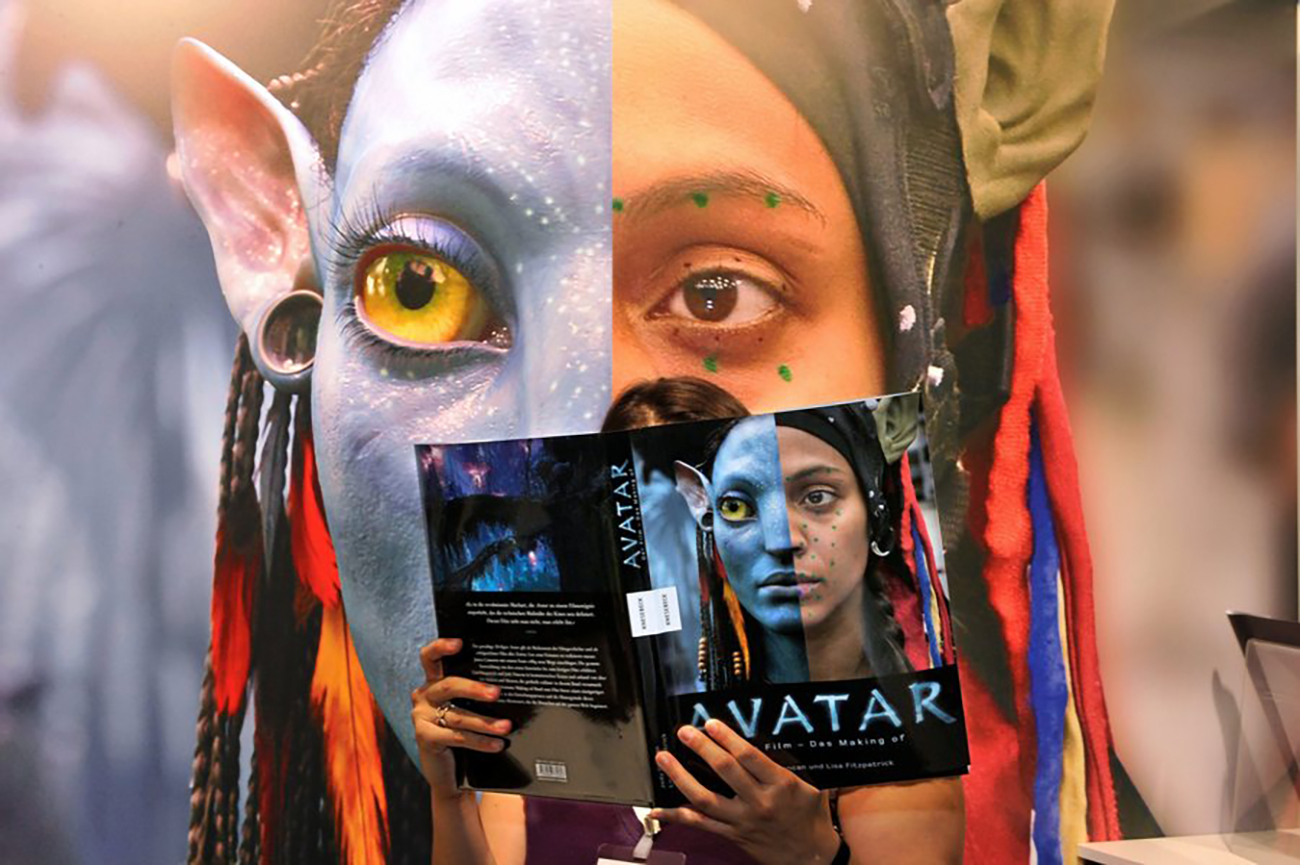 epa02377724 A woman reads a book on the making of the movie 'Avatar' at the Book Fair in Frankfurt Main, Germany, 06 October 2010. The fair for printed and digital books takes place from 06 to 10 October and features more than 7,000 exhibitors from 113 countries.  EPA