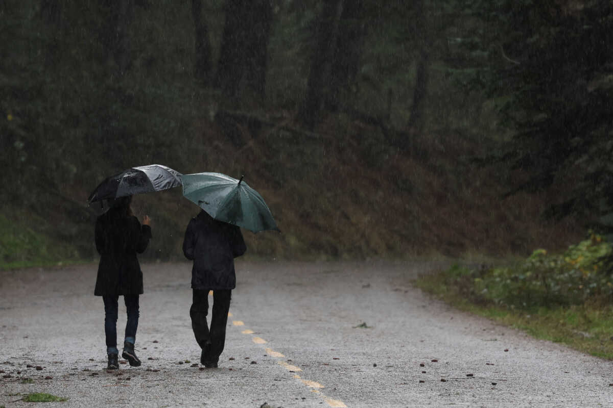 A couple walks in the rain after storms in Mendocino, California, U.S. January 5, 2023. REUTERS