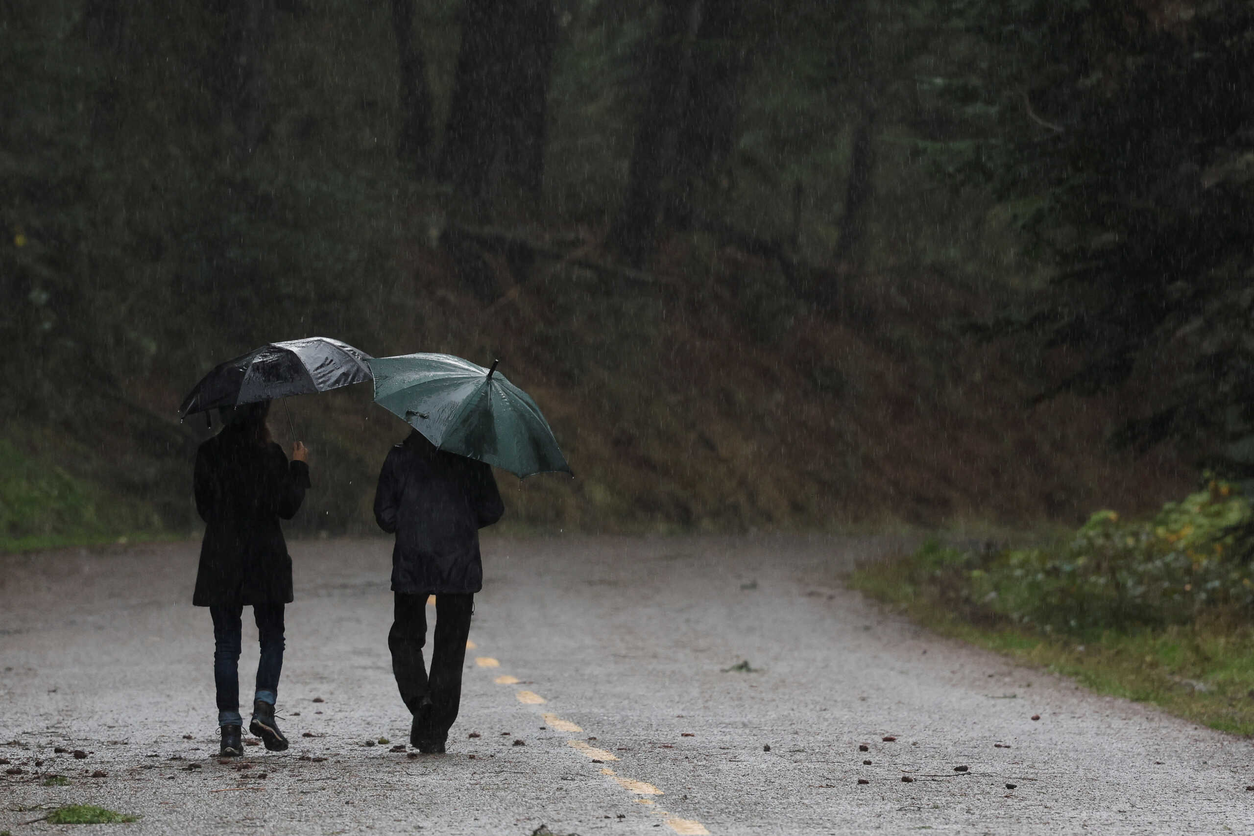 A couple walks in the rain after storms in Mendocino, California, U.S. January 5, 2023. REUTERS