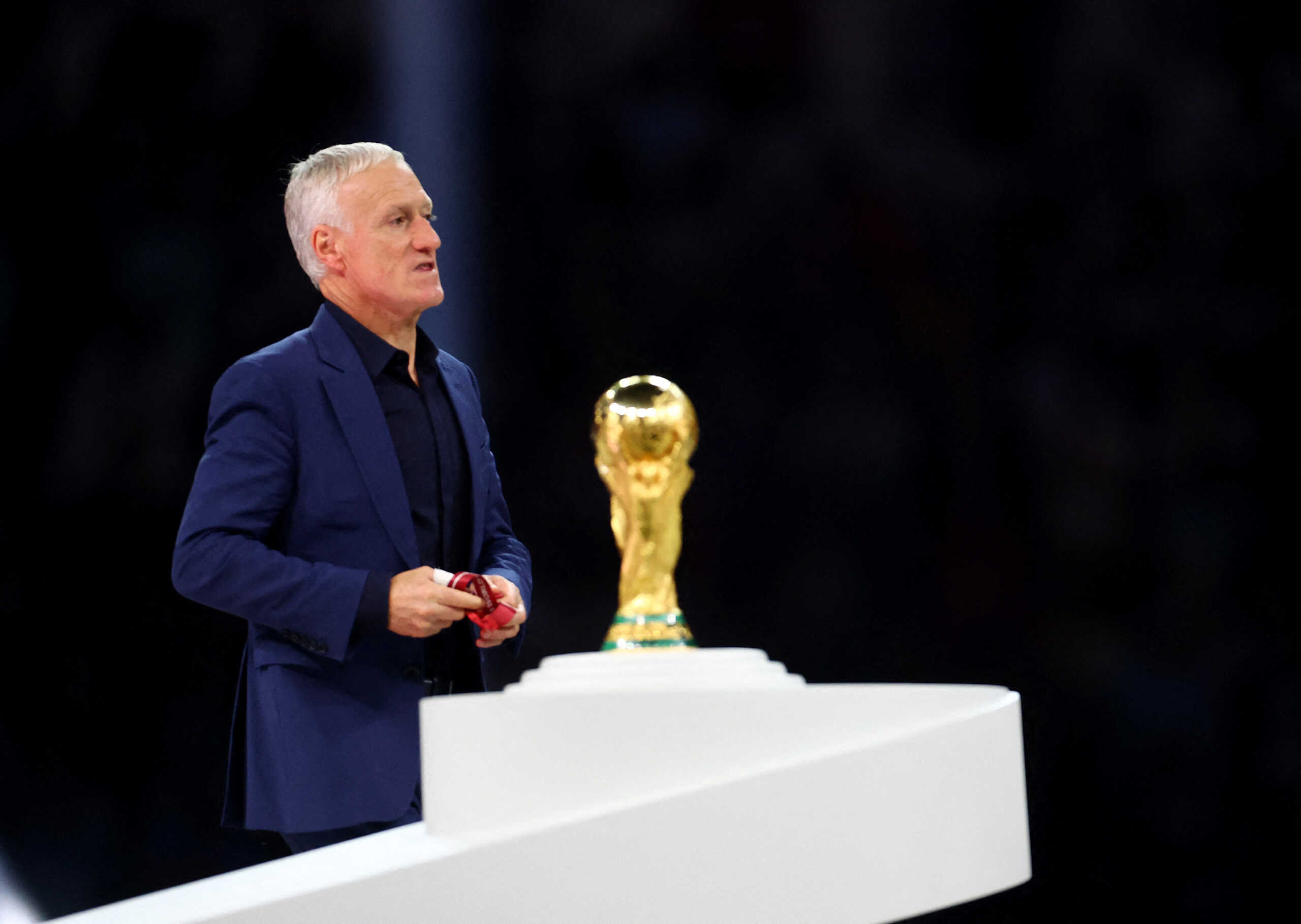 Soccer Football - FIFA World Cup Qatar 2022 - Final - Argentina v France - Lusail Stadium, Lusail, Qatar - December 18, 2022   France coach Didier Deschamps looks dejected as he walks past the trophy during the trophy ceremony REUTERS