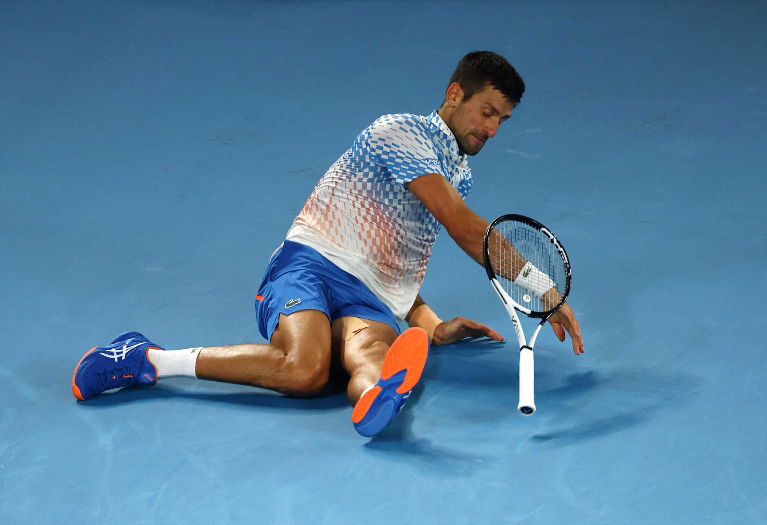 Tennis - Australian Open - Men's Singles Final - Melbourne Park, Melbourne, Australia - January 29, 2023 Serbia's Novak Djokovic falls during his final match against Greece's Stefanos Tsitsipas REUTERS