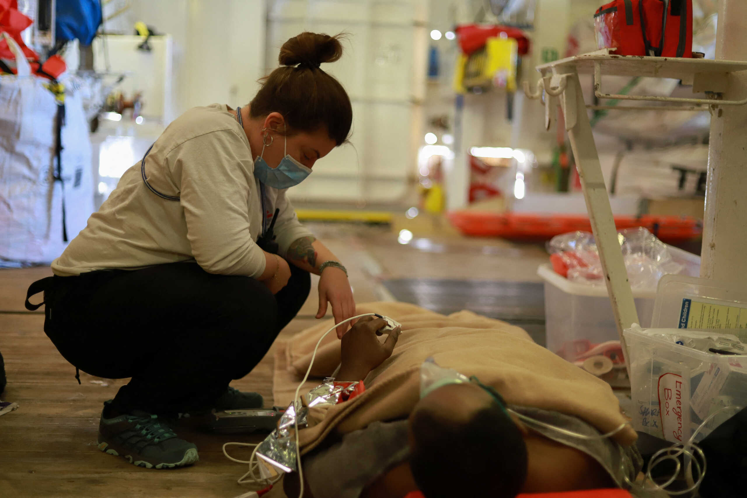 A member of Doctors Without Borders (MSF) looks at a migrant after he was rescued by the ship 'Geo Barents' during a search and rescue (SAR) operation in the Mediterranean Sea, January 25, 2023. Mohamad Cheblak