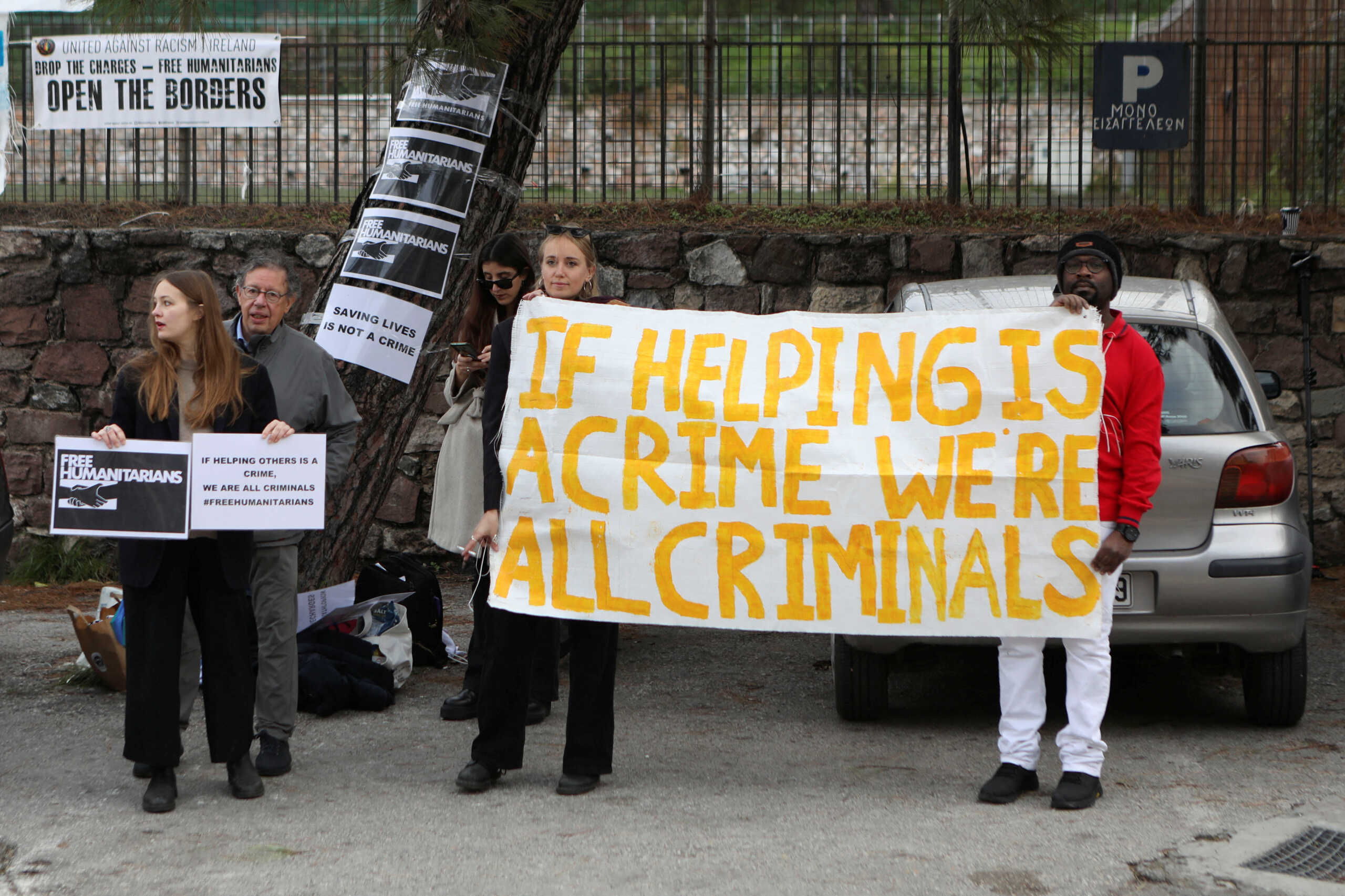 Aid worker Pieter Wittenberg, who faces trial over refugee rescues, stands next to supporters holding a banner, outside a courthouse on the island of Lesbos, Greece, January 13, 2023. REUTERS