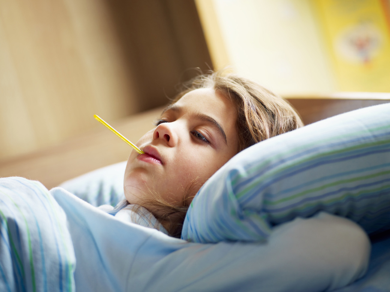 girl taking temperature in bed. Copy space
