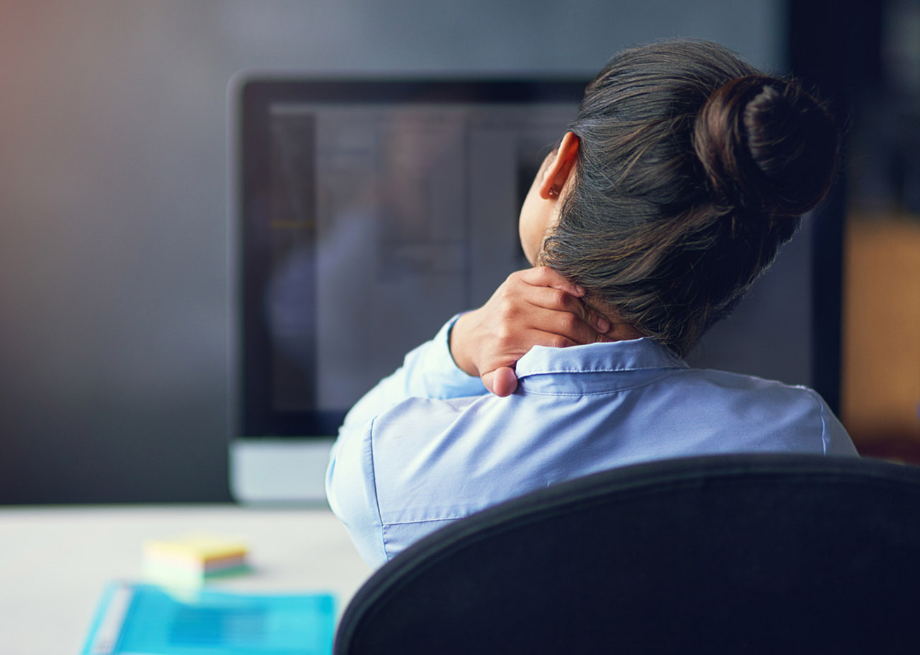Rearview shot of a businesswoman suffering from neck pain at the officehttp: