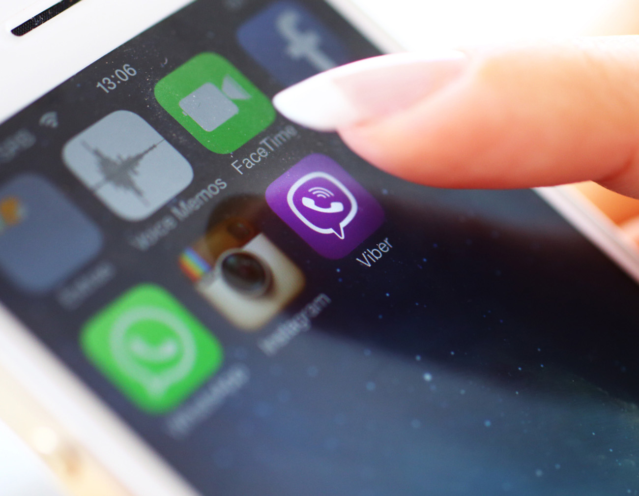 Wien,Austria-February 25,2014: Closeup of female hand holding an iPhone 5s while launching Viber,a popular messaging application .